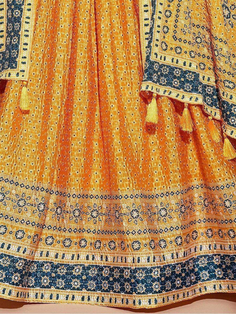 Orange and blue printed ethnic lehenga with tassels and intricate border patterns