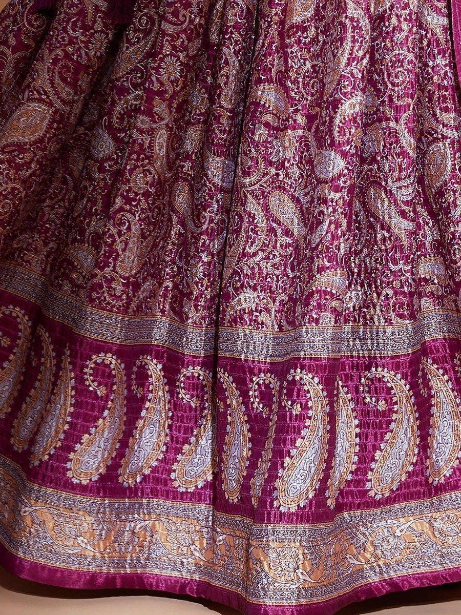 Rich maroon lehenga with intricate gold paisley embroidery and detailed border design