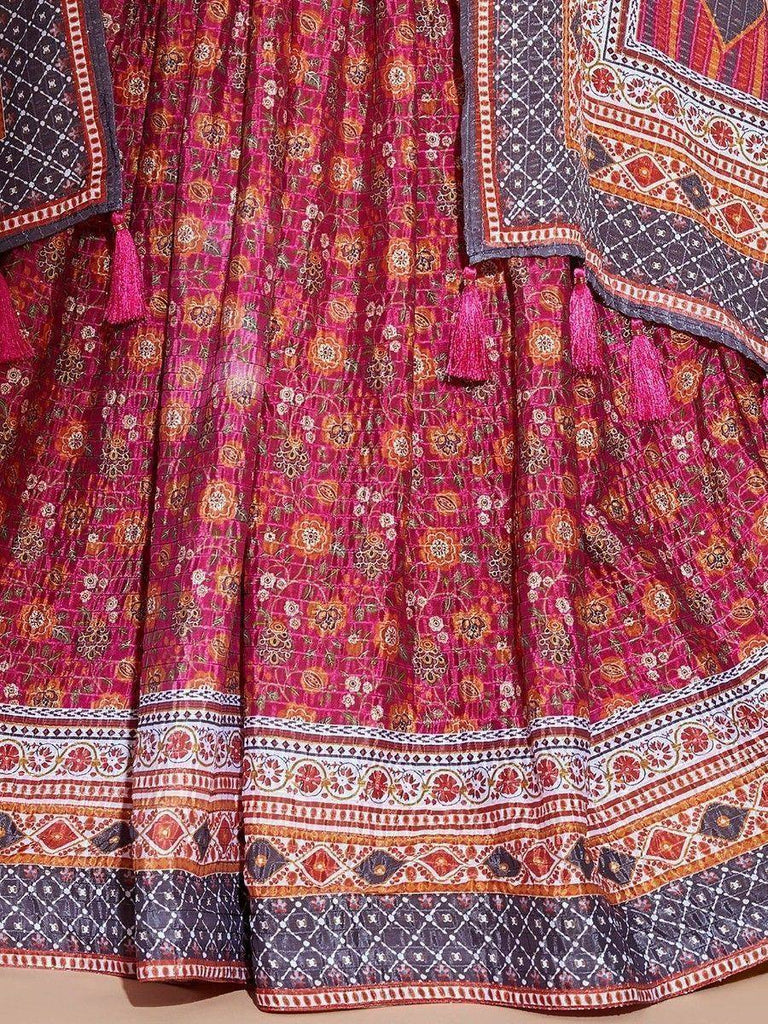Vibrant pink floral printed lehenga with ethnic border and tassels, ideal for Indian weddings and festivals