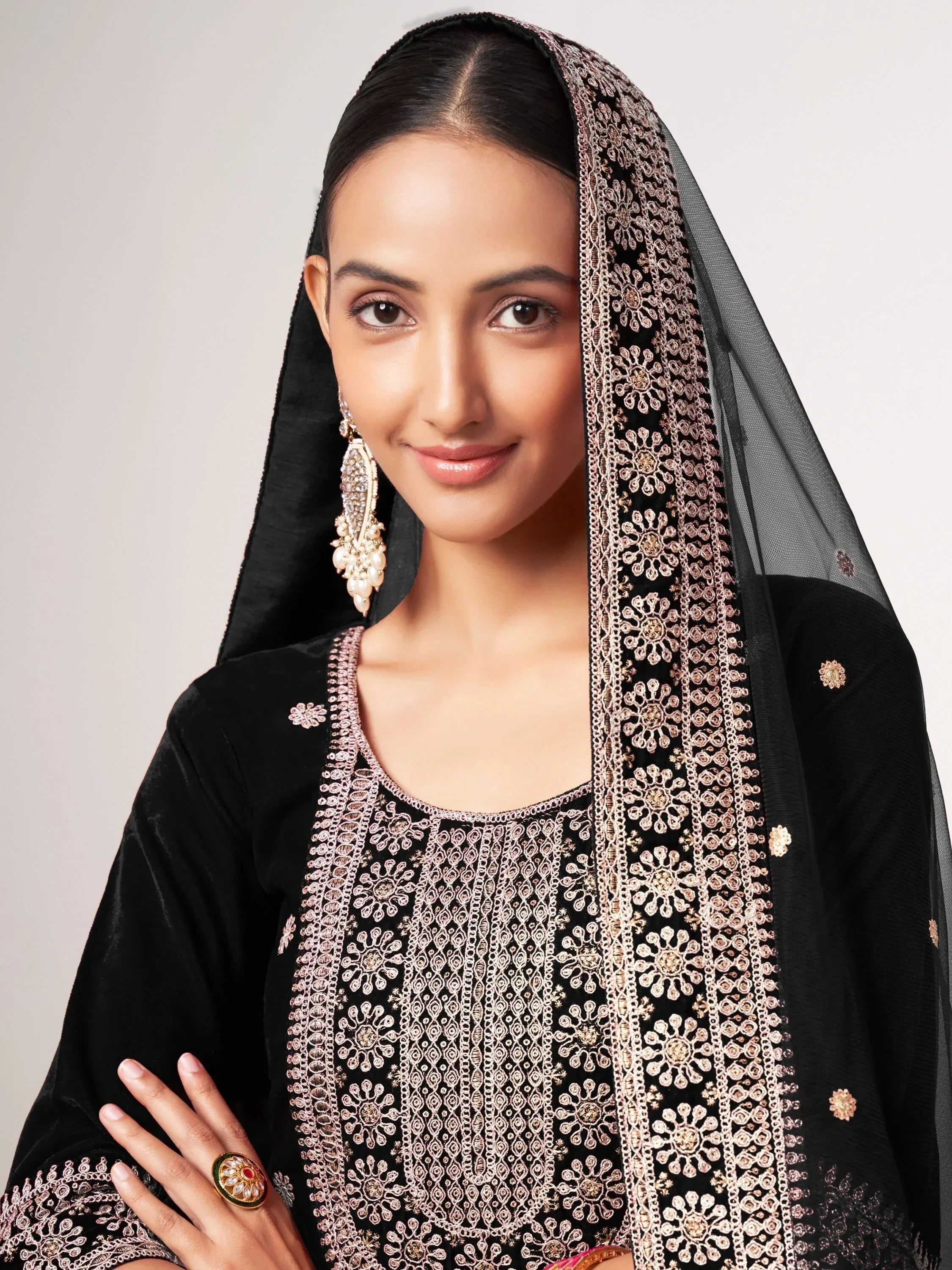 Woman in black velvet ethnic suit with gold floral embroidery and matching dupatta
