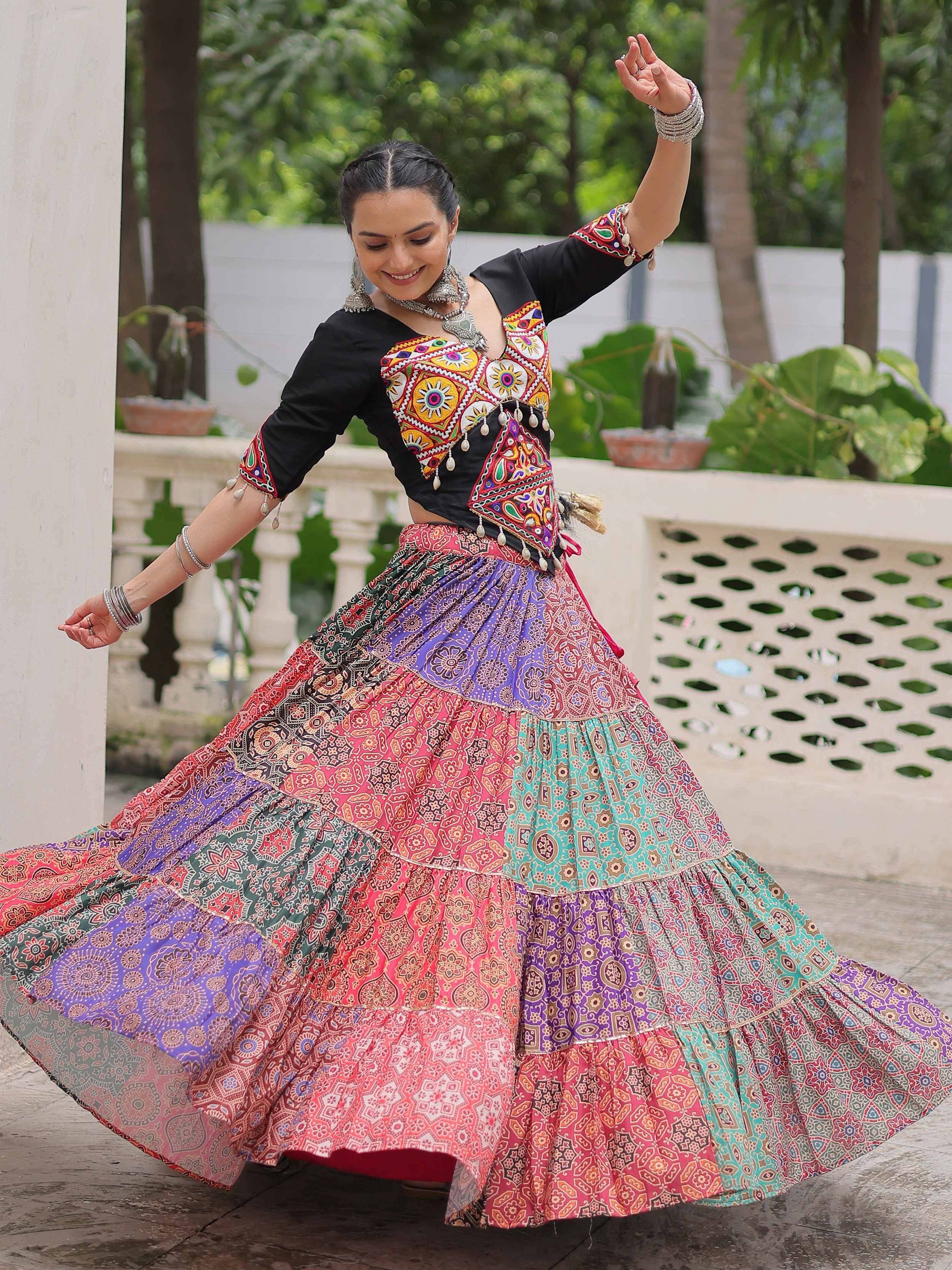 Woman dancing in vibrant Indian ethnic wear with colorful patchwork skirt and embroidered top