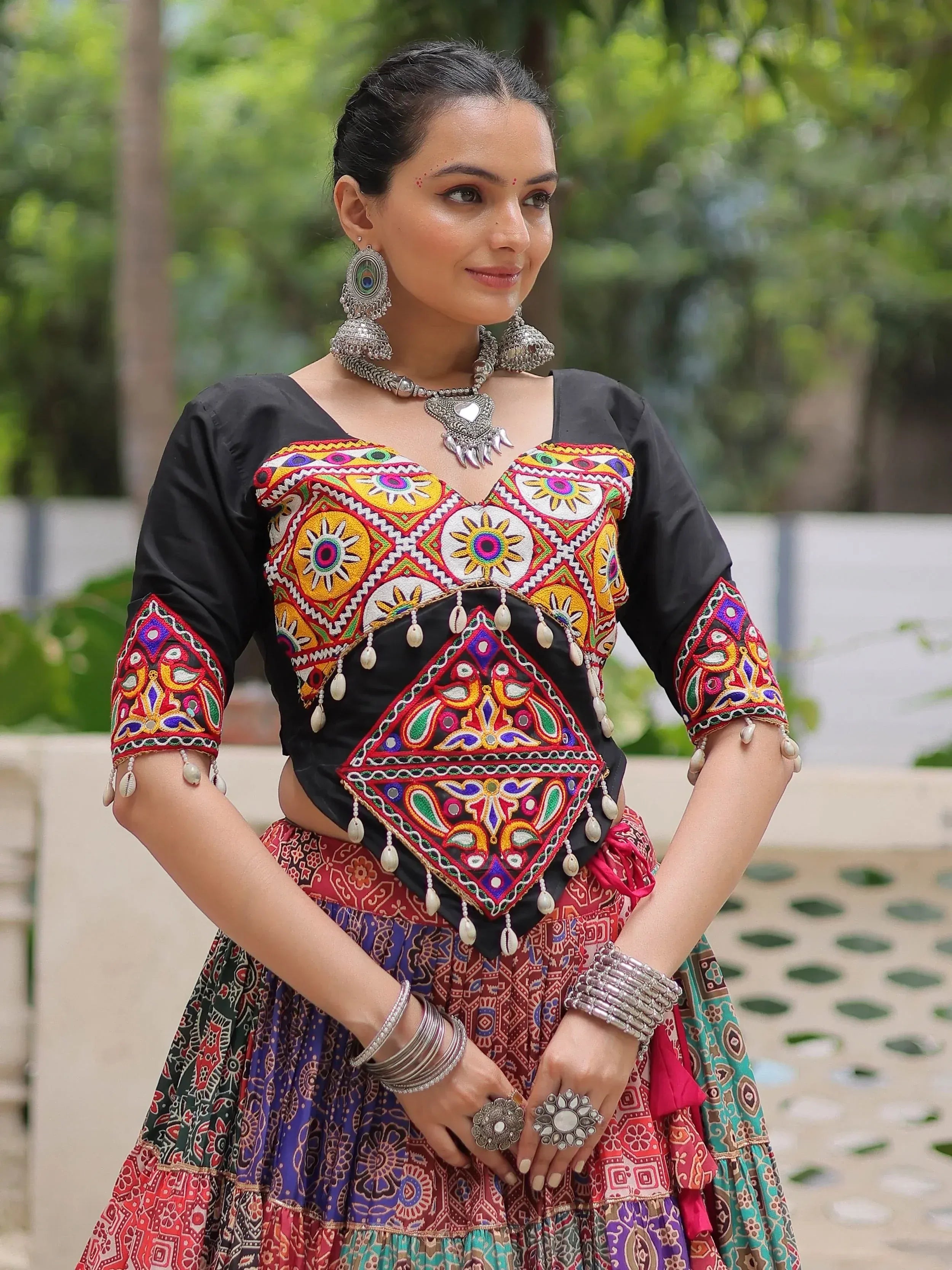 Colorful embroidered ethnic blouse with mirror work and traditional jewelry