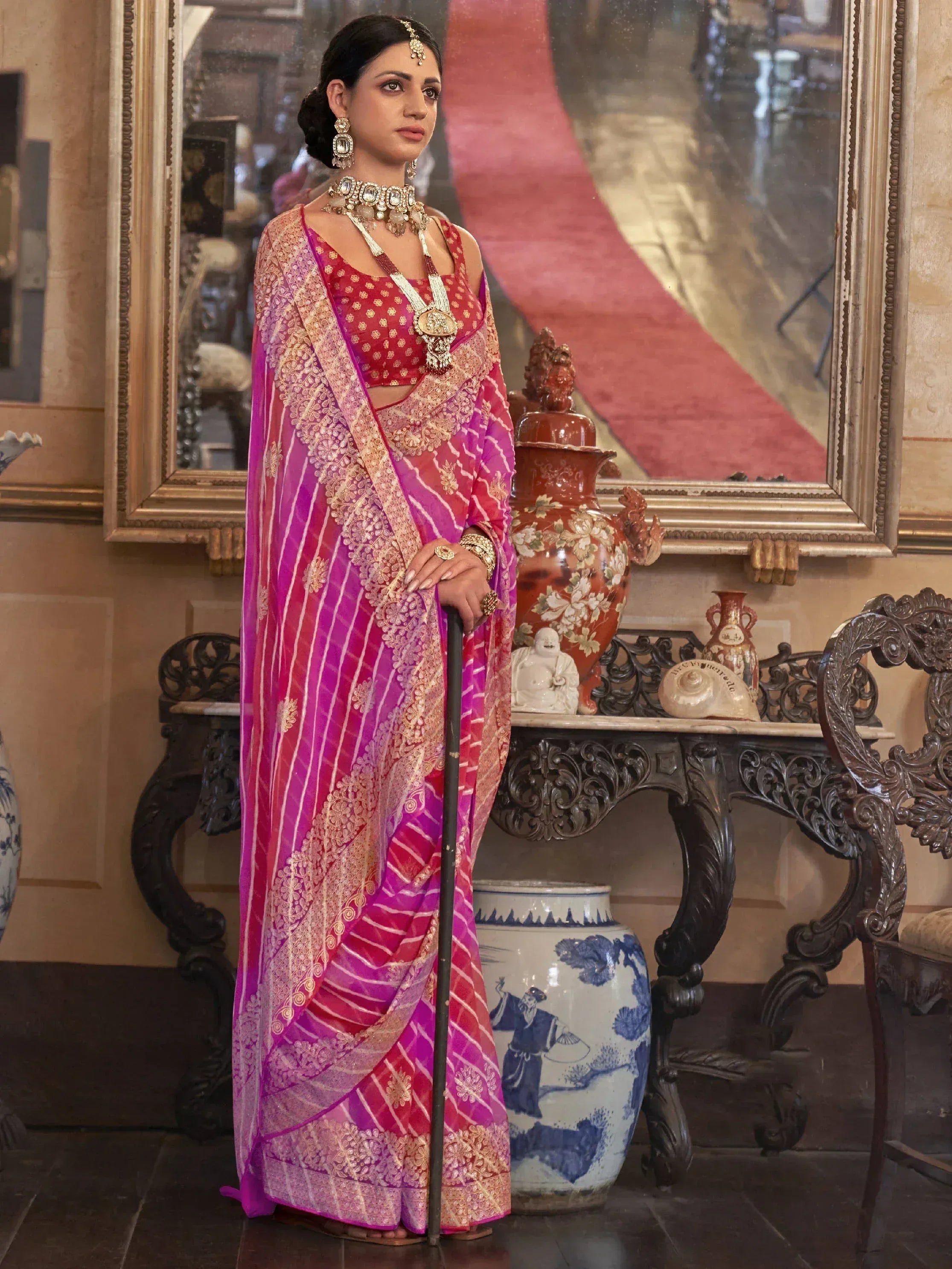 Elegant woman in pink and gold embroidered saree with traditional jewelry, perfect for Indian ethnic wear occasions.