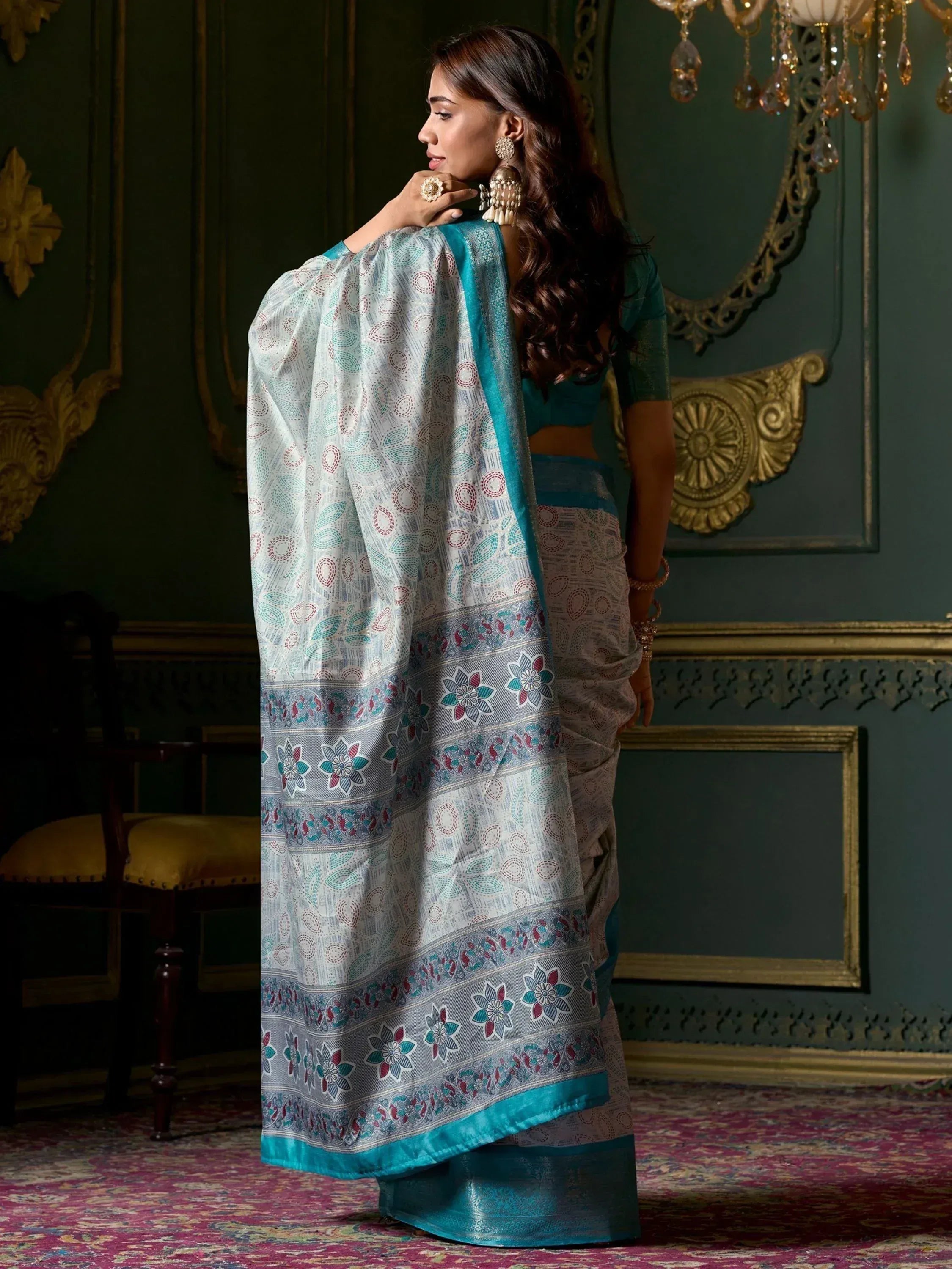 Woman in elegant printed saree with teal border, ethnic Indian wear for festive occasions