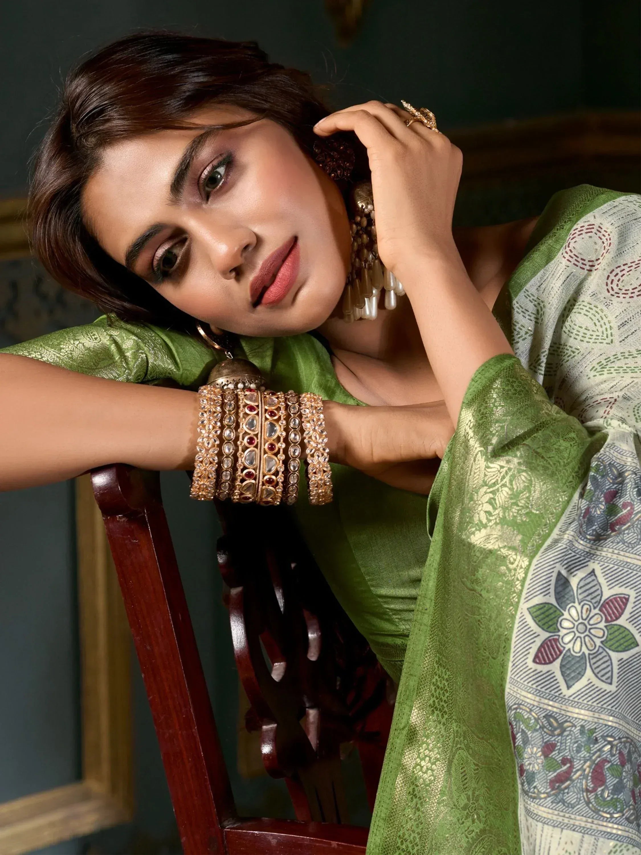 Woman in green ethnic saree with gold jewelry, traditional Indian wear for festive occasions