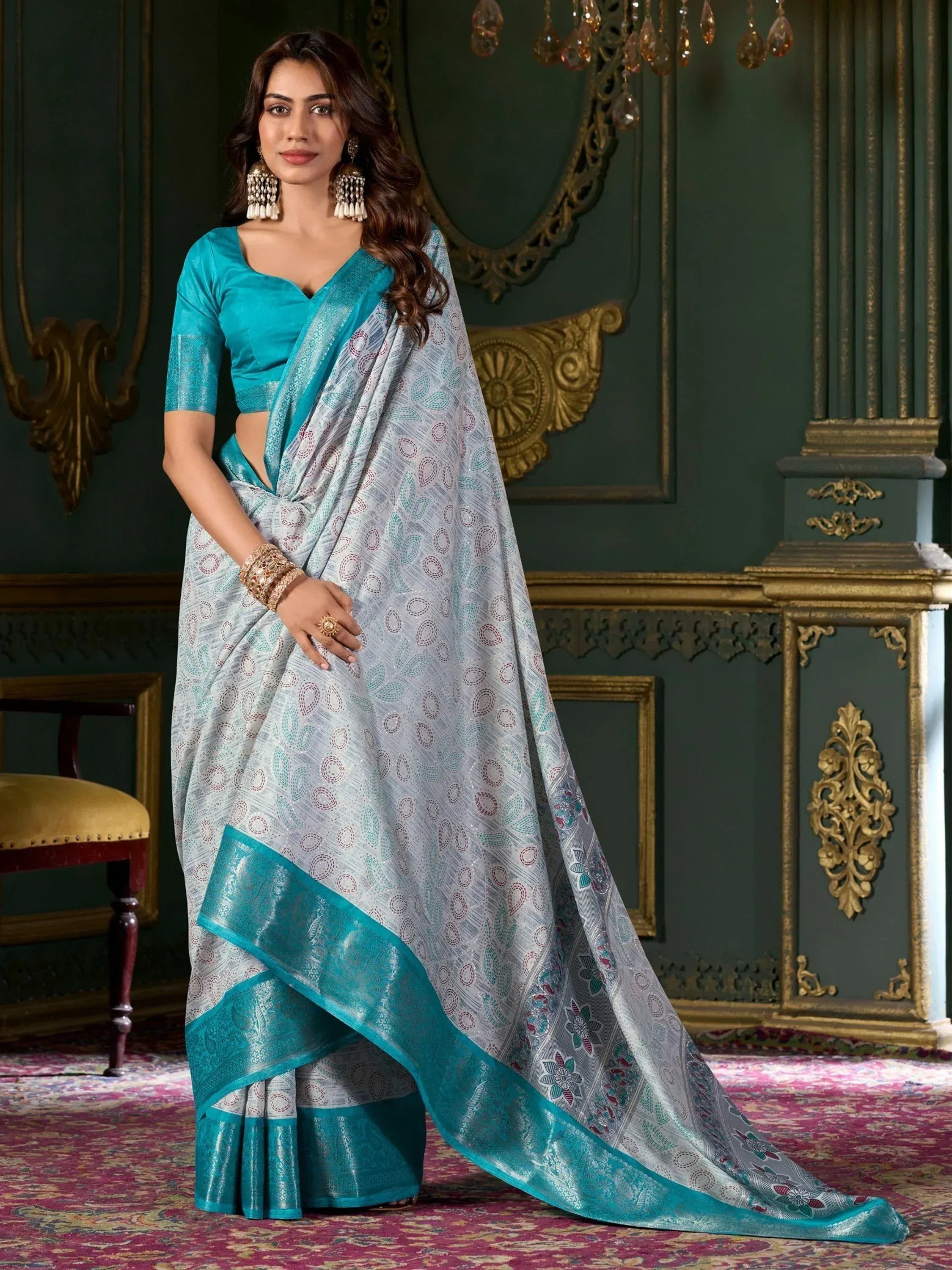 Elegant silver and teal saree with intricate paisley print and rich border, paired with matching blouse for festive occasions