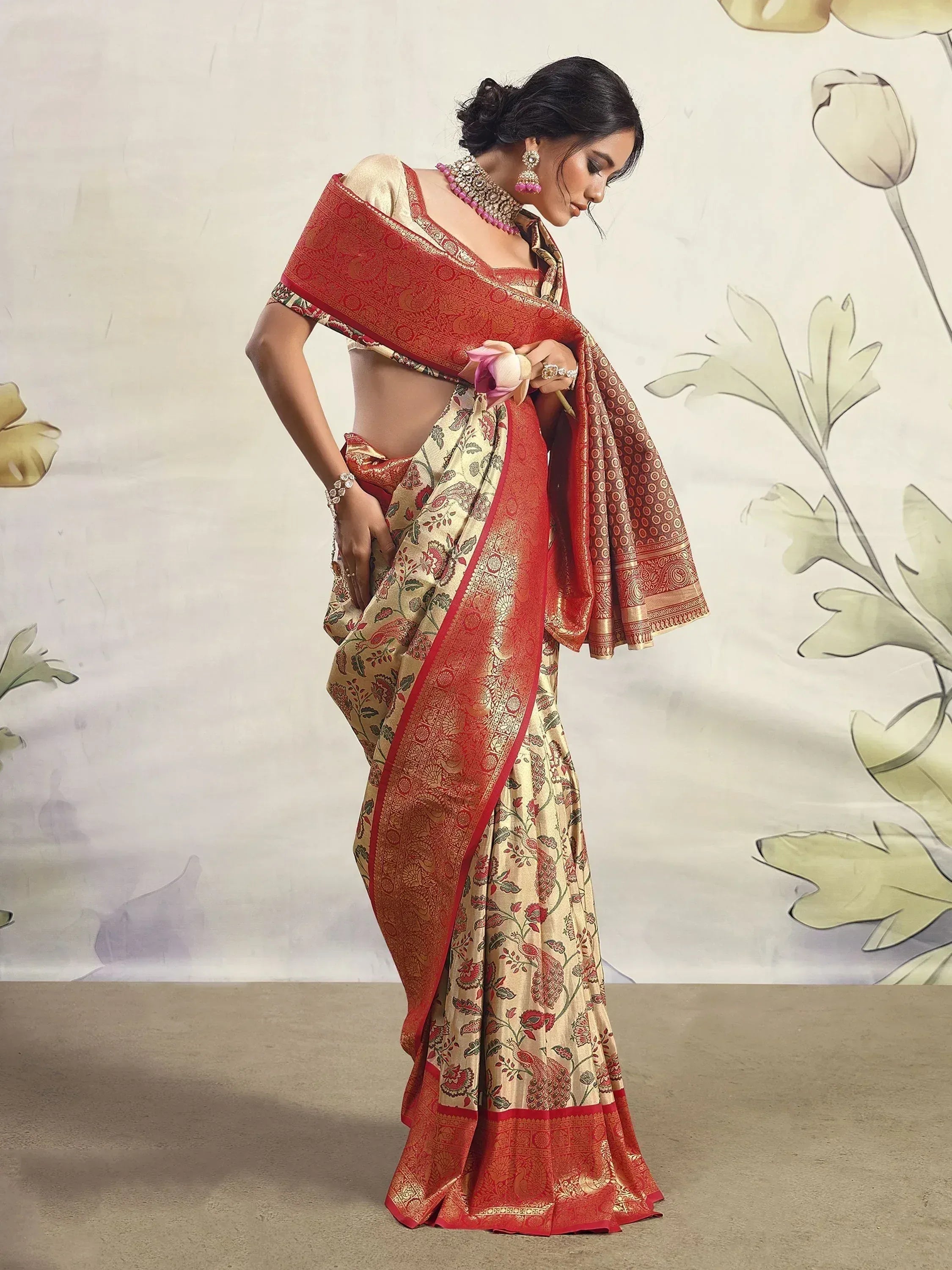 Elegant woman in cream and red floral saree with gold border, traditional Indian ethnic wear