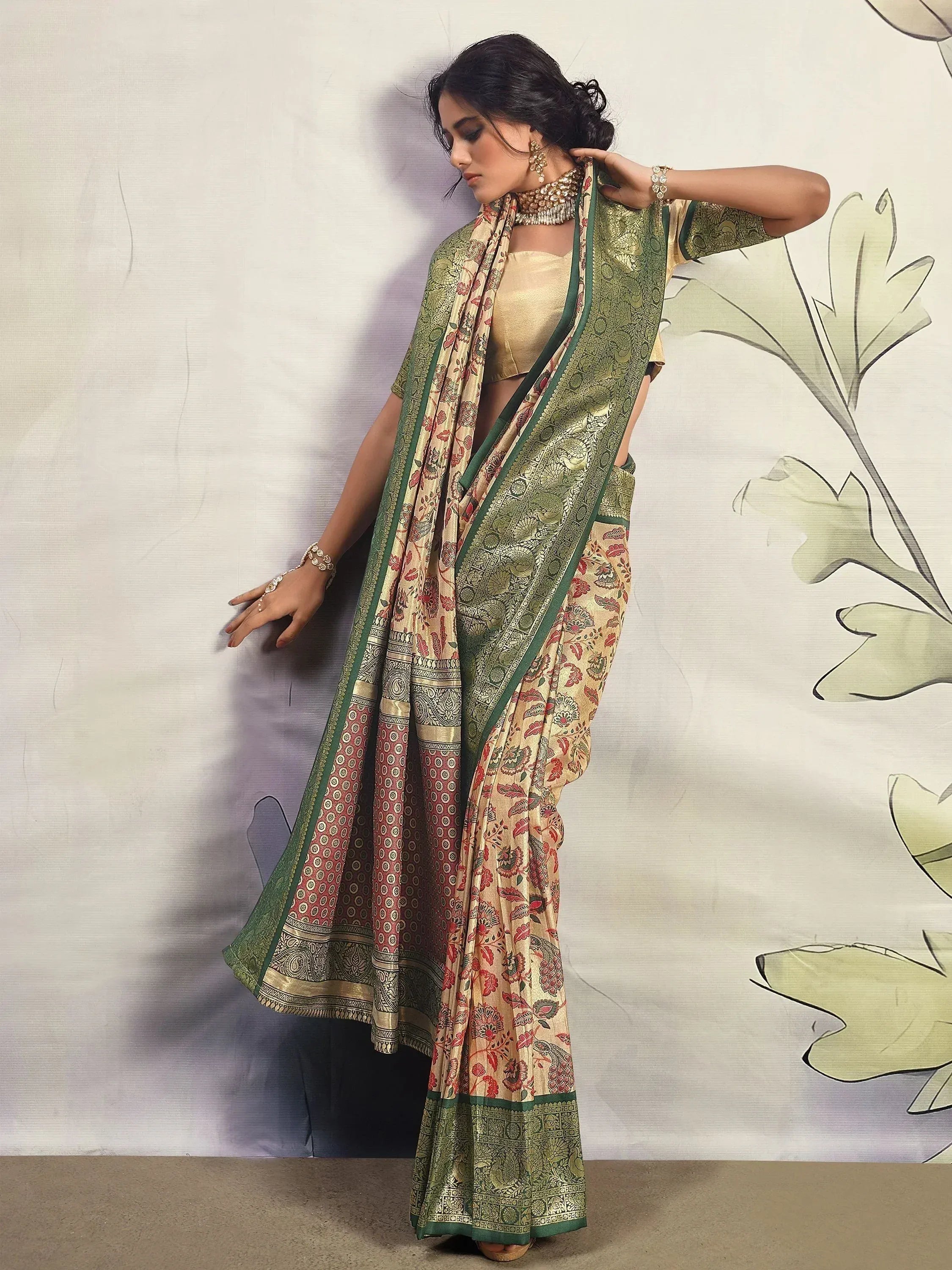 Elegant Indian saree with floral print and green border, paired with gold blouse for festive occasions.