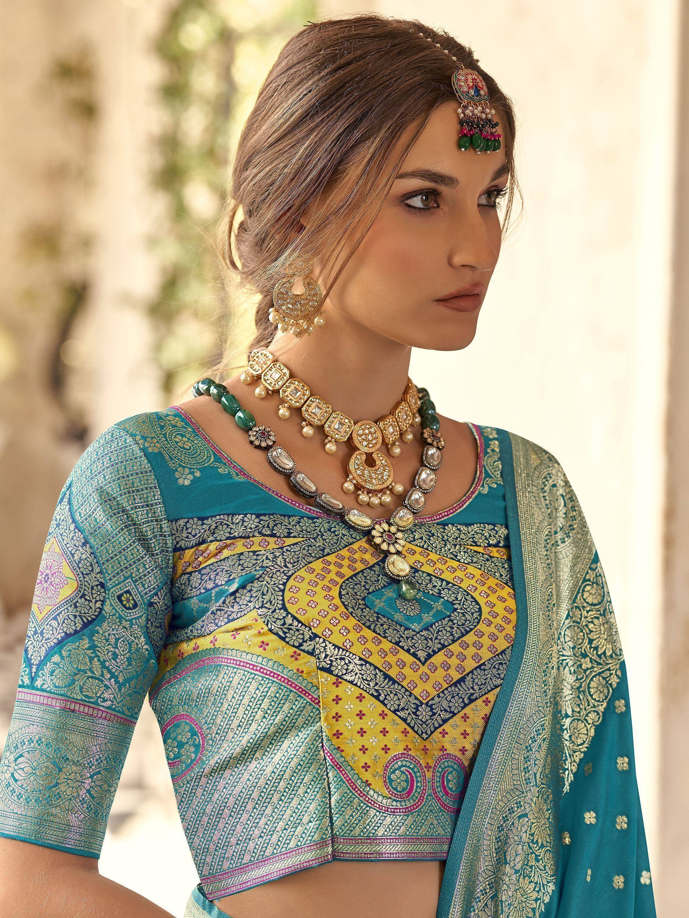 Teal and gold designer lehenga choli with intricate embroidery and traditional Indian jewelry