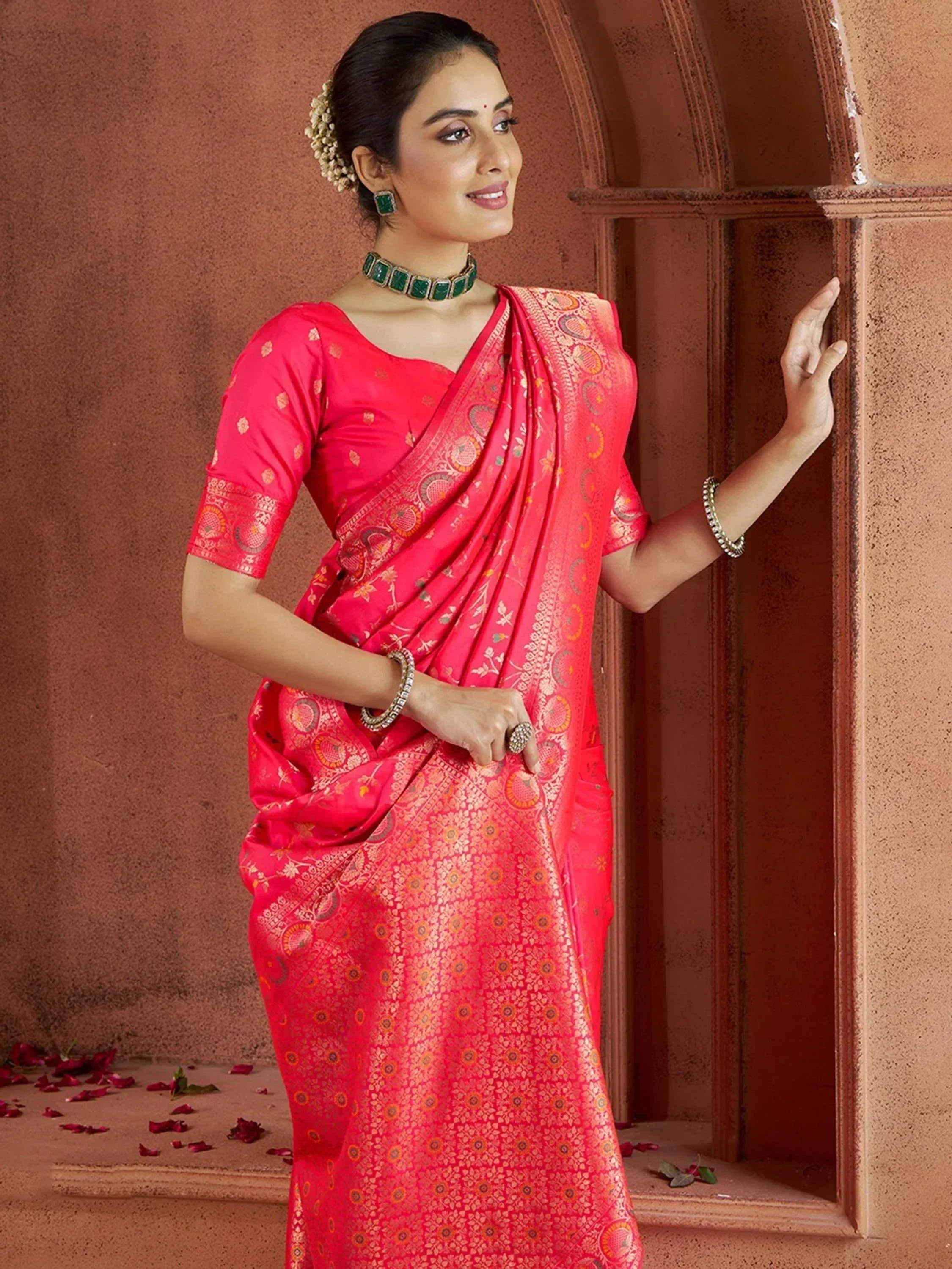 Woman in vibrant pink designer saree with gold floral patterns, traditional Indian ethnic wear
