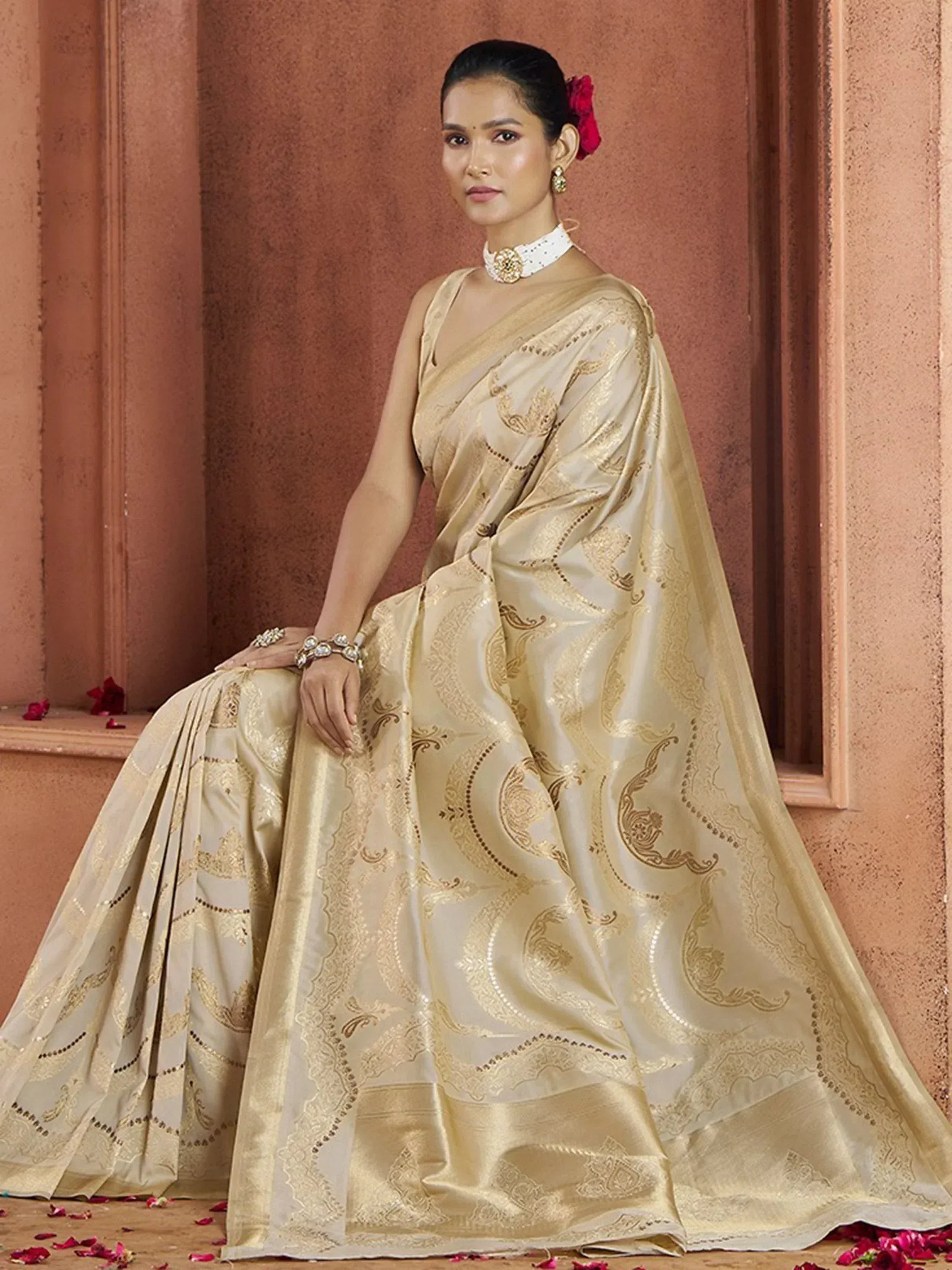 Elegant cream and gold designer saree with intricate paisley embroidery, perfect for Indian ethnic occasions.