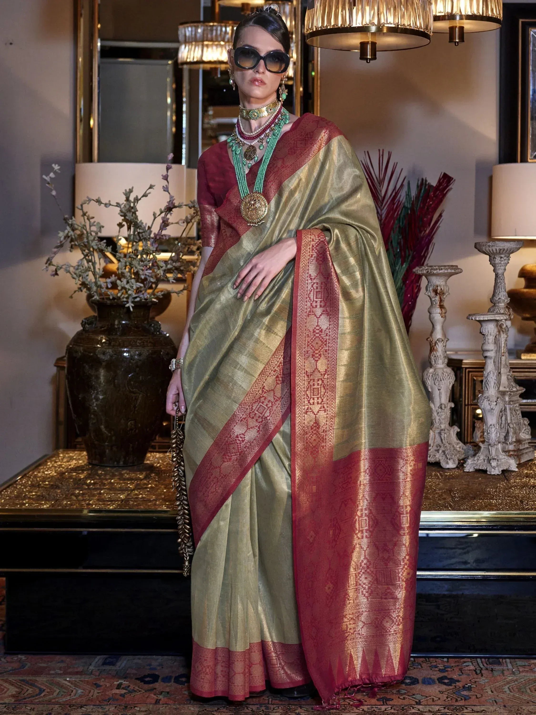 Elegant olive green and maroon silk saree with intricate gold border, paired with traditional jewelry for festive occasions