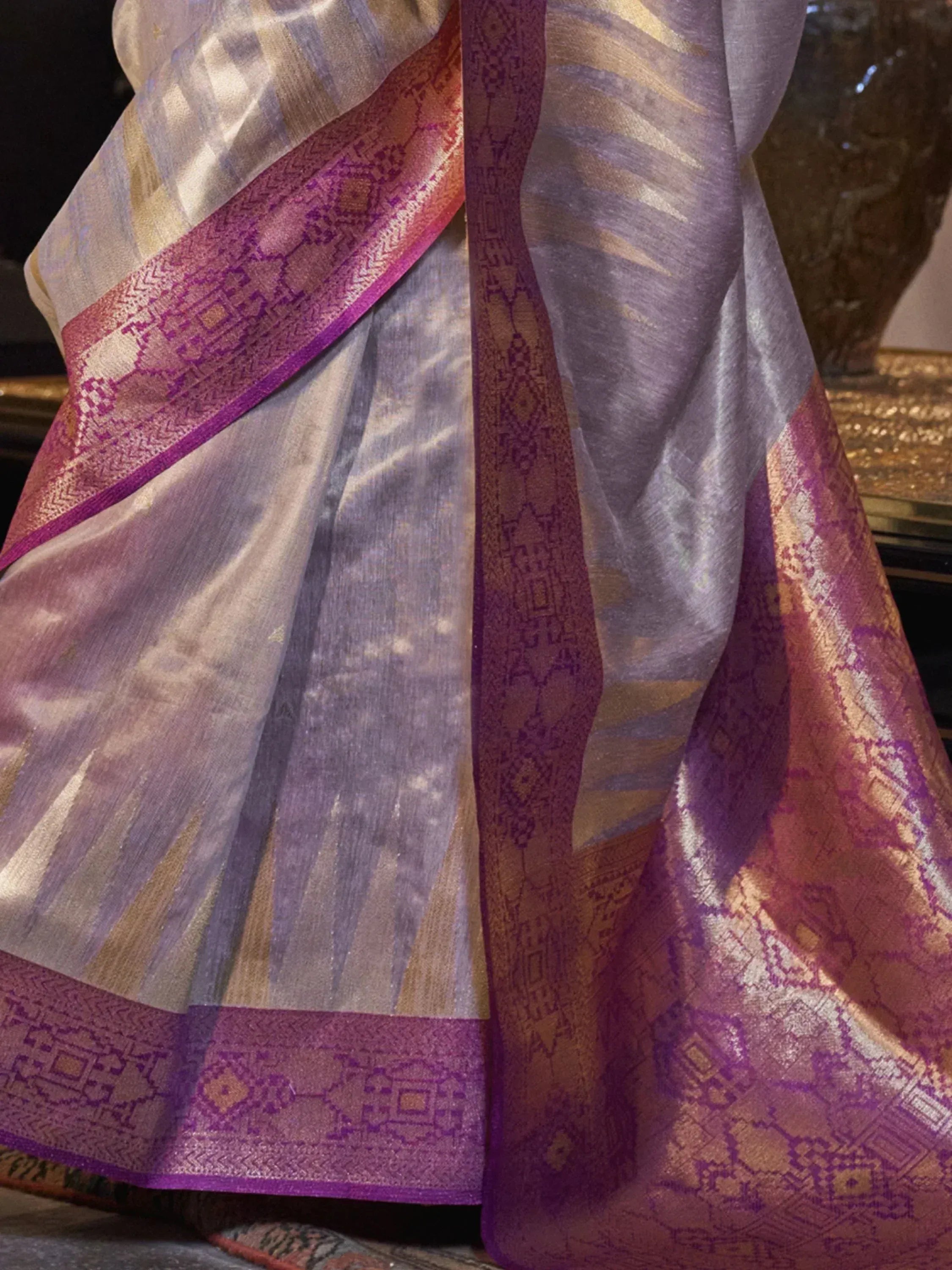 Elegant purple and gold designer saree with intricate woven border, perfect for Indian ethnic wear occasions.