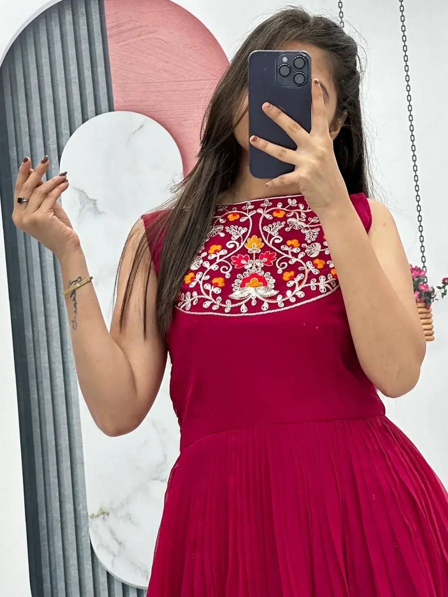 Woman in maroon ethnic gown with floral embroidery, taking mirror selfie