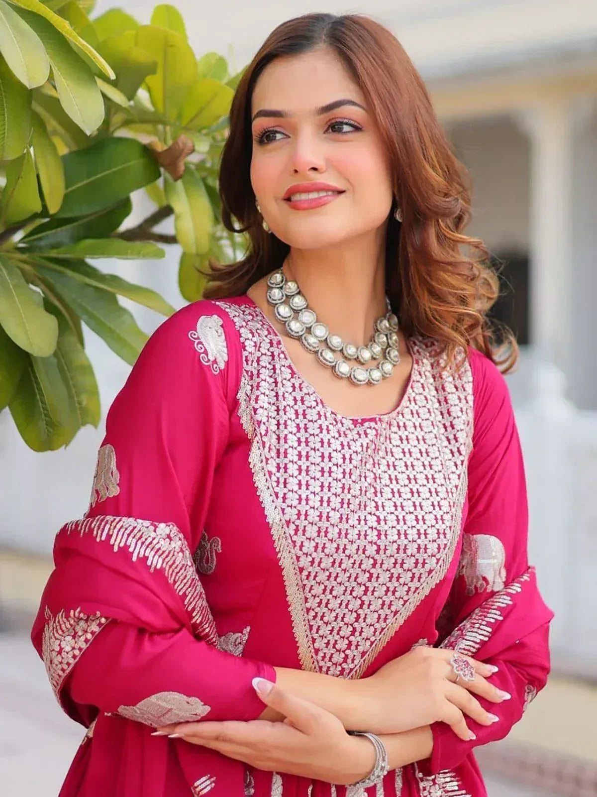 Elegant pink embroidered salwar kameez with intricate white detailing and statement jewelry
