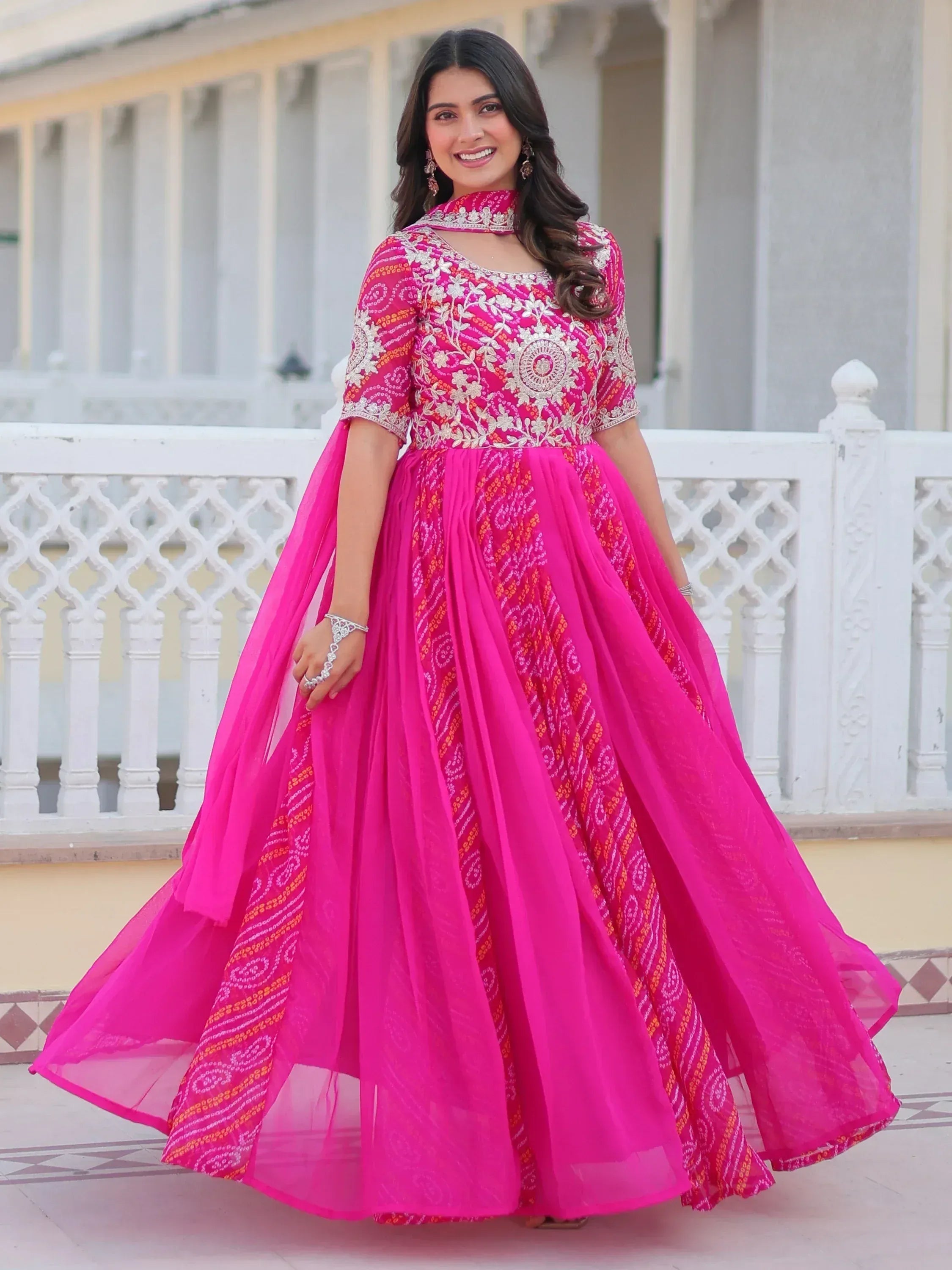 Pink embroidered ethnic gown with floral motifs and flared skirt, perfect for Indian celebrations