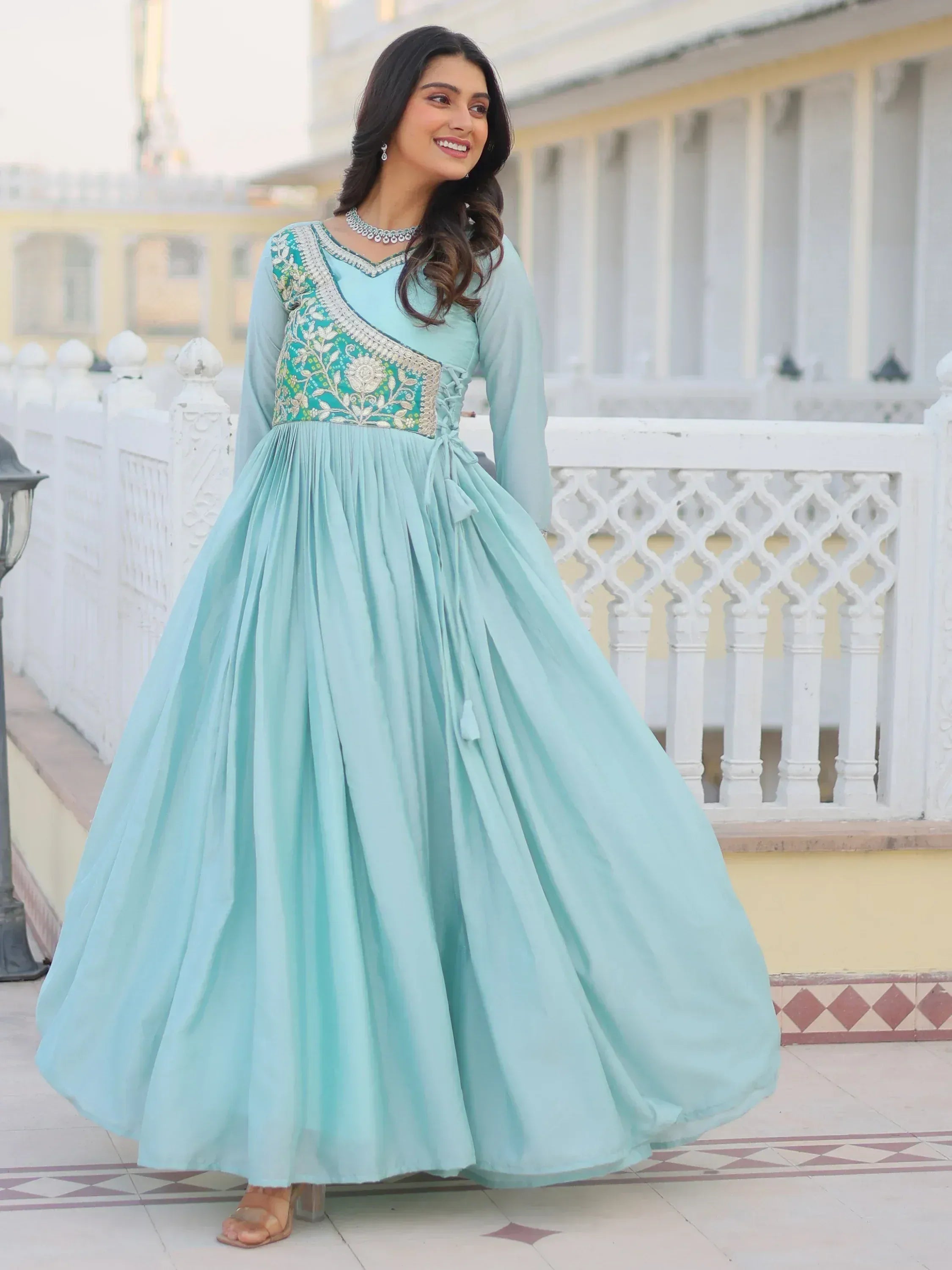 Elegant mint green ethnic gown with floral embroidery and pleated skirt, perfect for festive occasions.