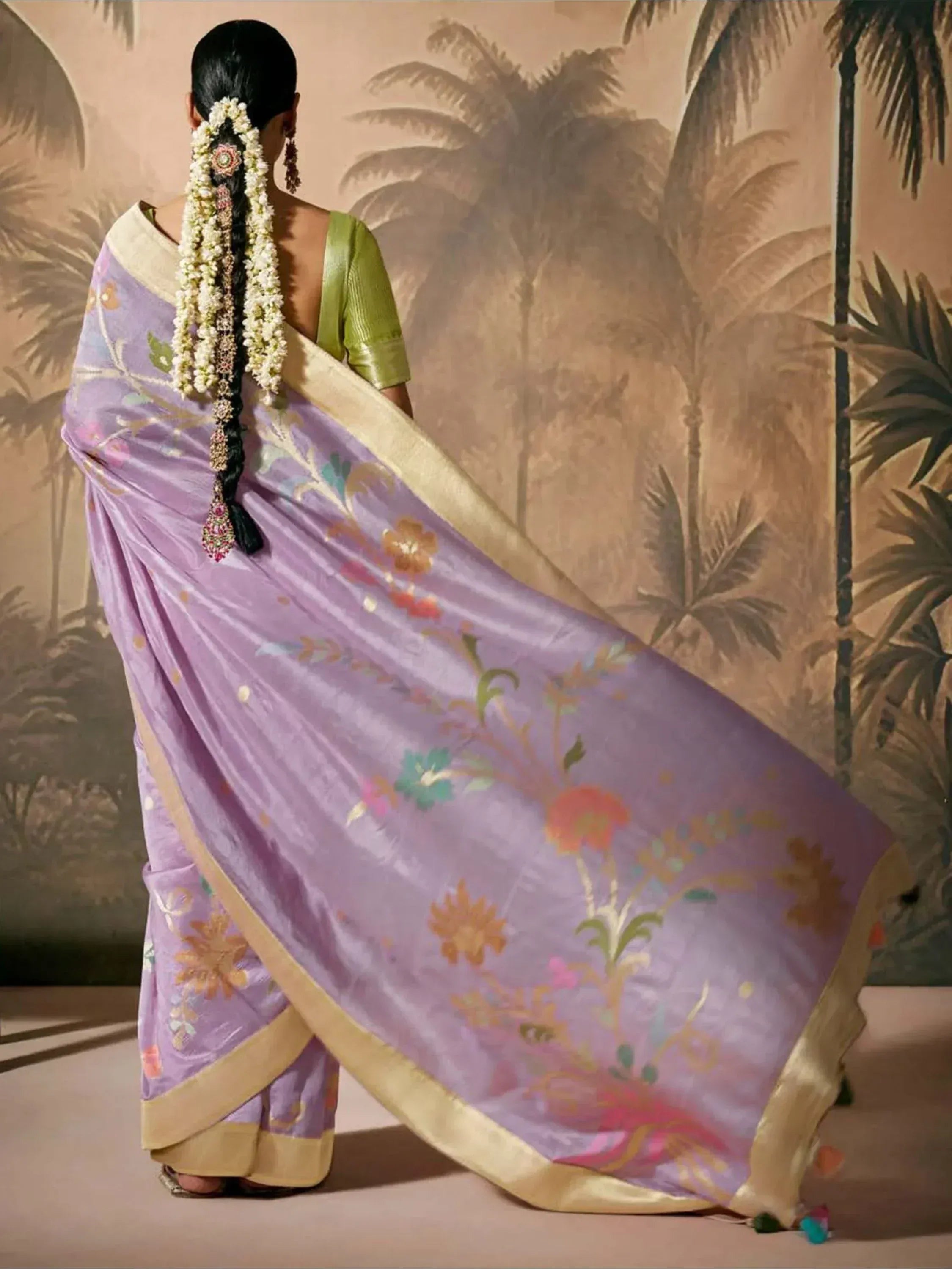 Lavender floral saree with gold border, green blouse, and traditional hair accessories for ethnic wear
