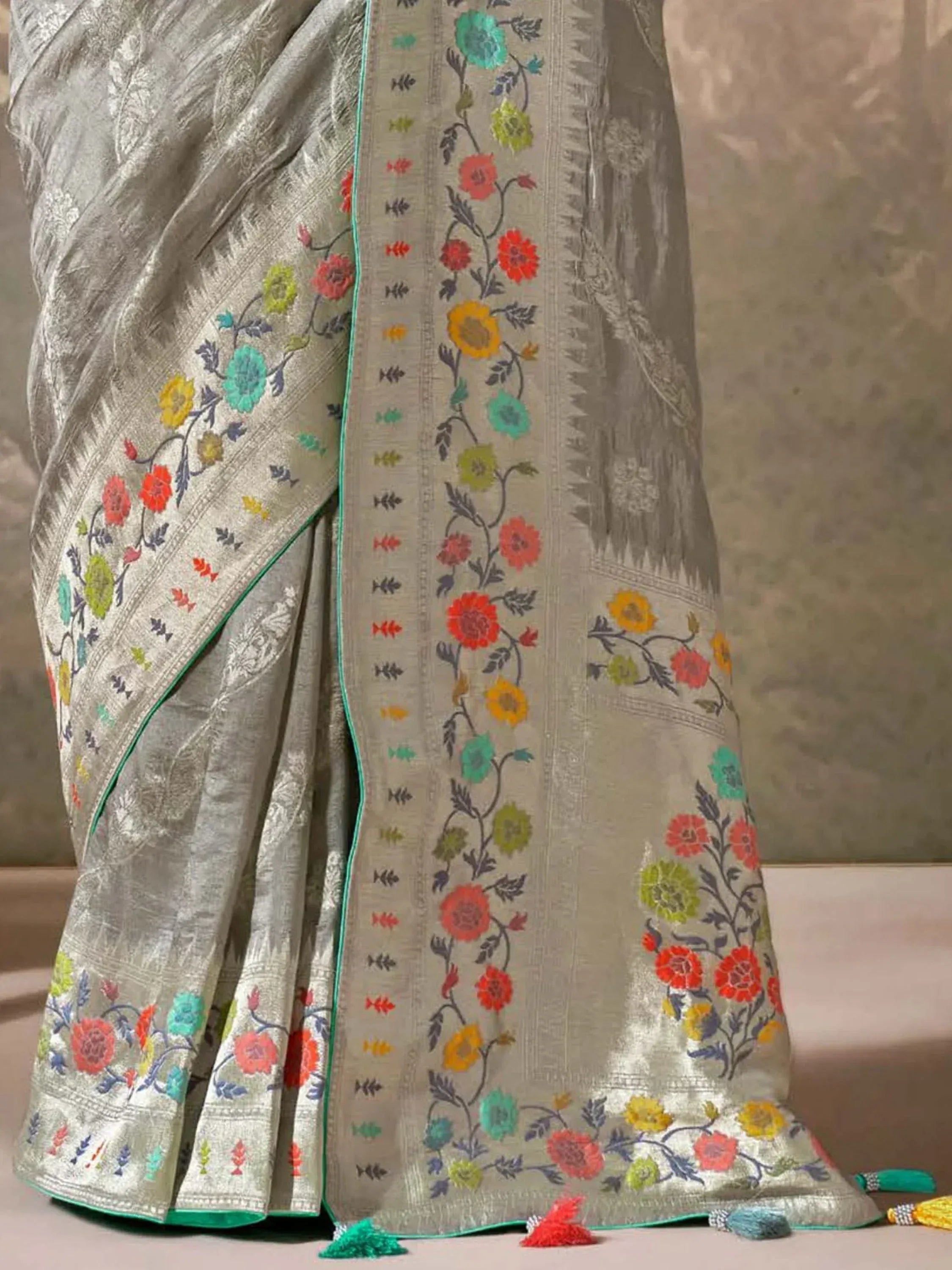 Silver floral embroidered saree with colorful motifs and tassels, ideal for ethnic occasions