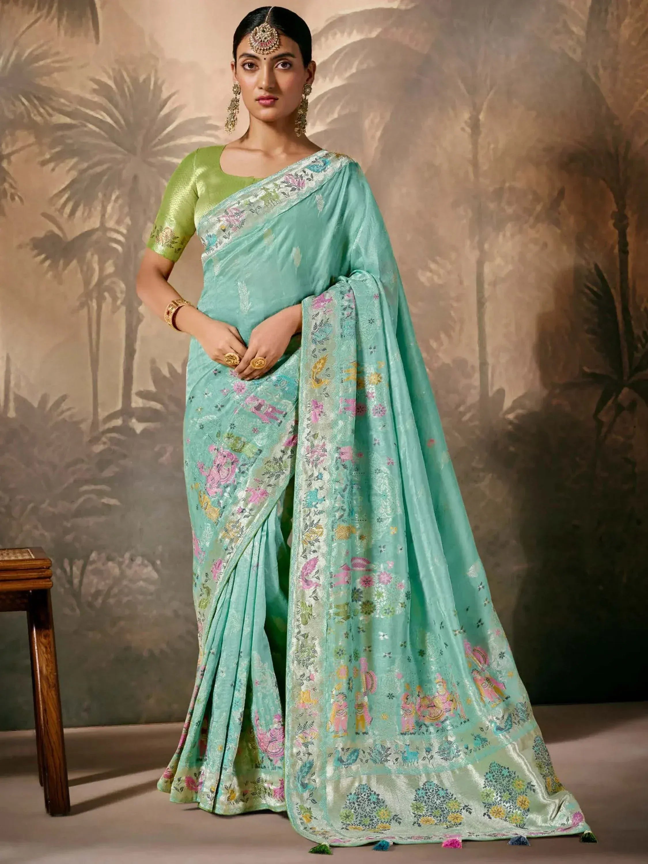 Mint green embroidered saree with floral and animal motifs, paired with green blouse, ideal for Indian ethnic occasions.