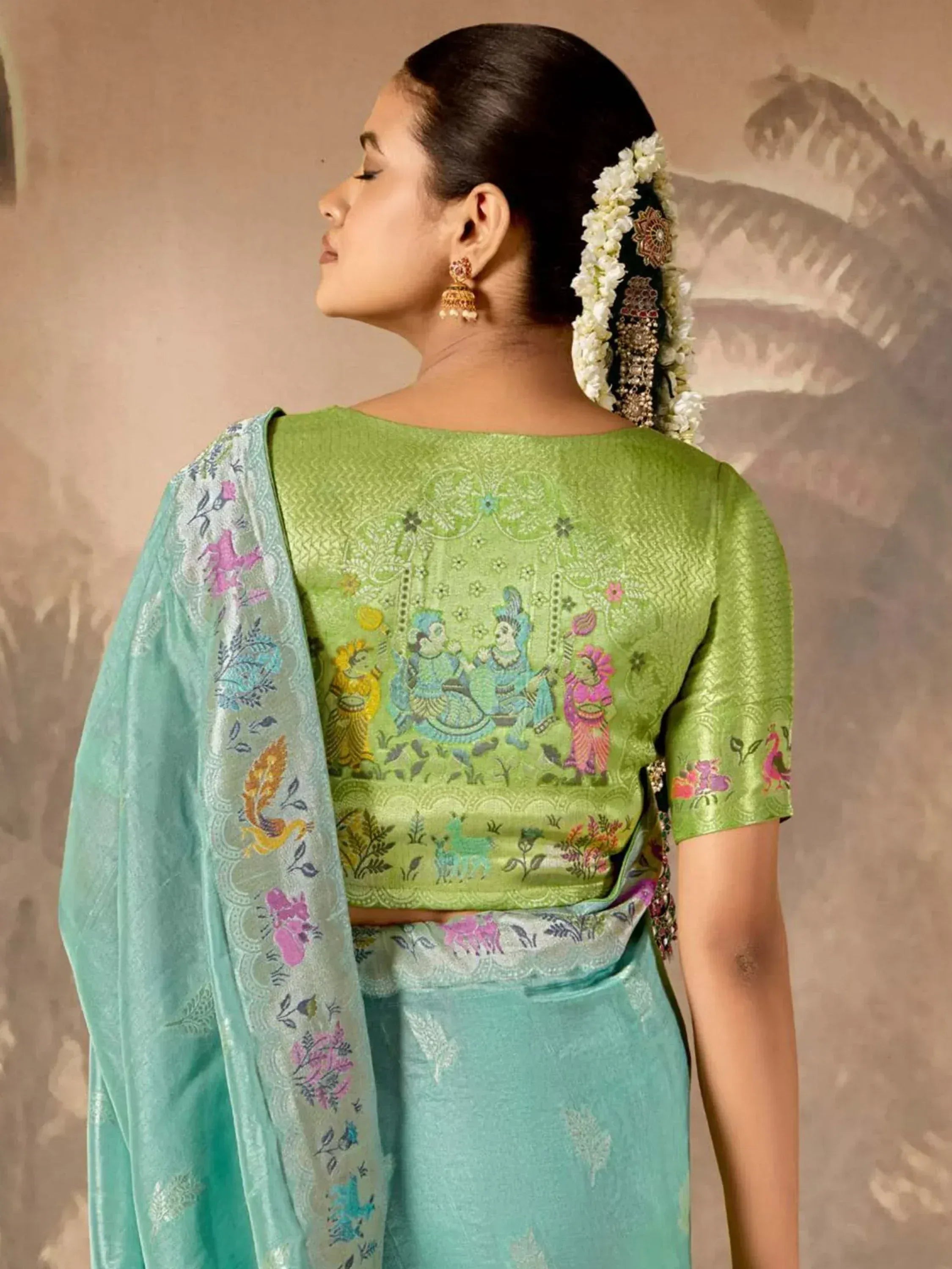 Green embroidered saree with floral and figurative motifs, traditional Indian ethnic wear