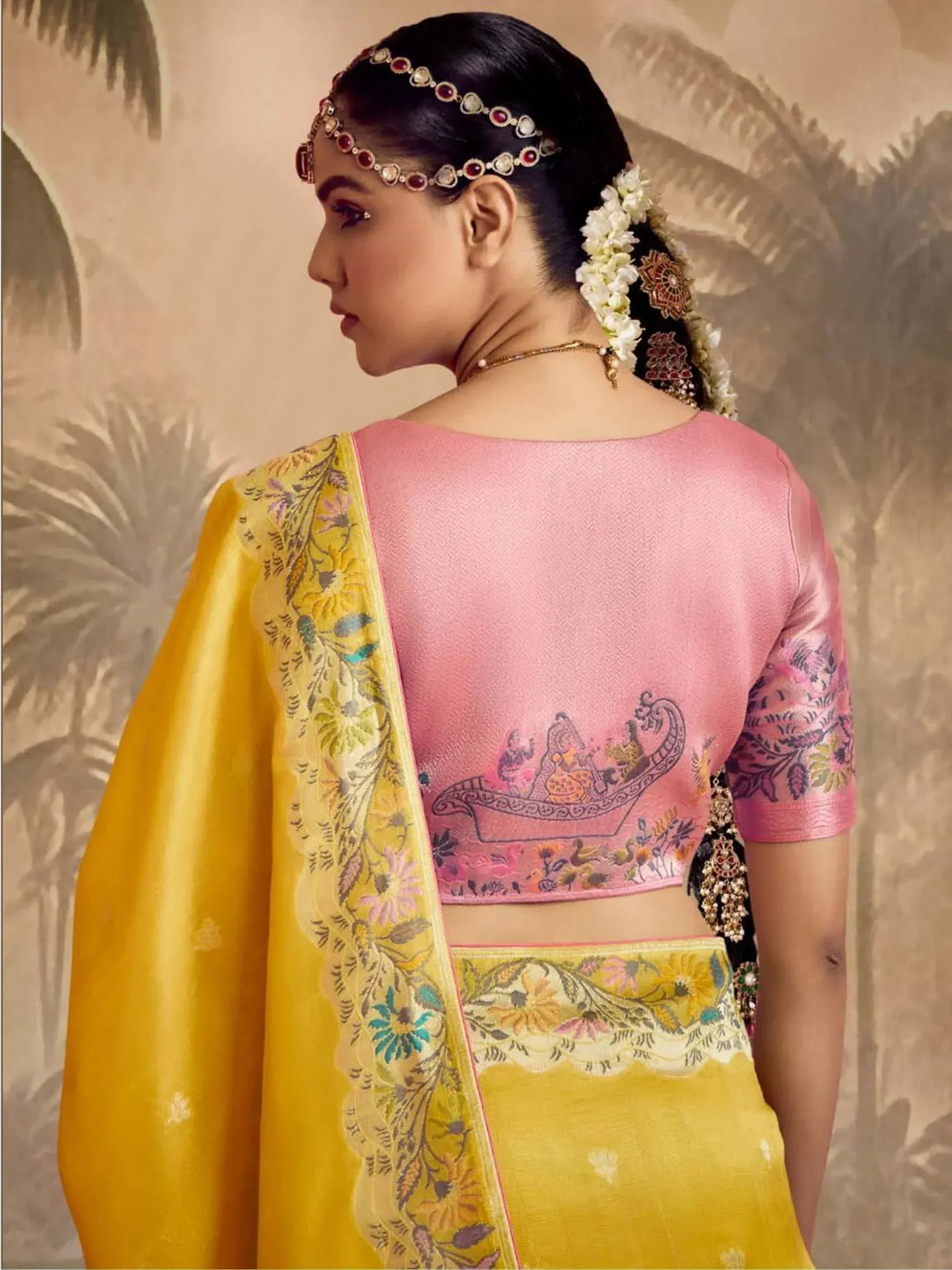 Pink and yellow designer lehenga choli with floral embroidery and traditional jewelry