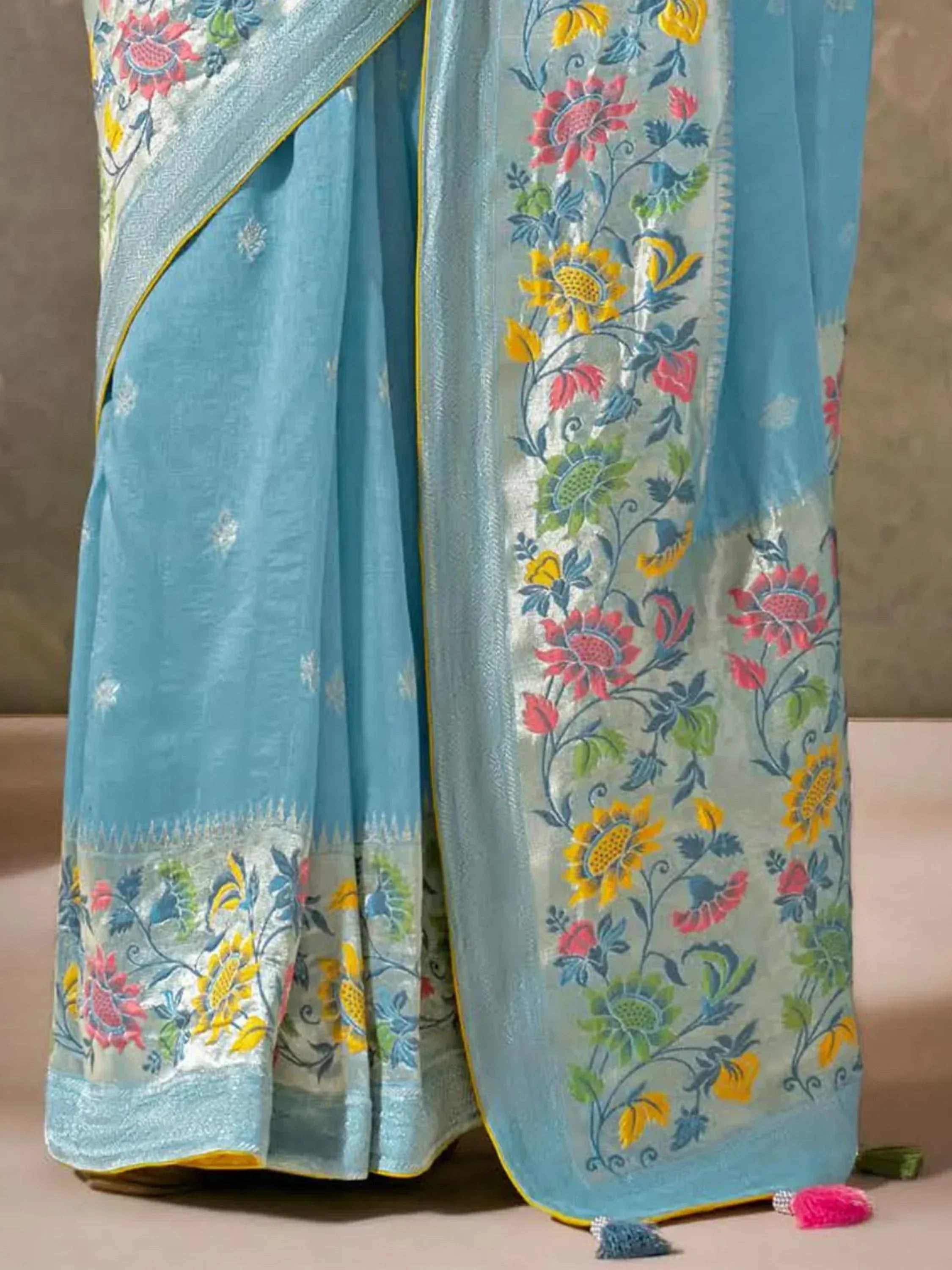Light blue saree with vibrant floral embroidery and yellow border, perfect for ethnic occasions