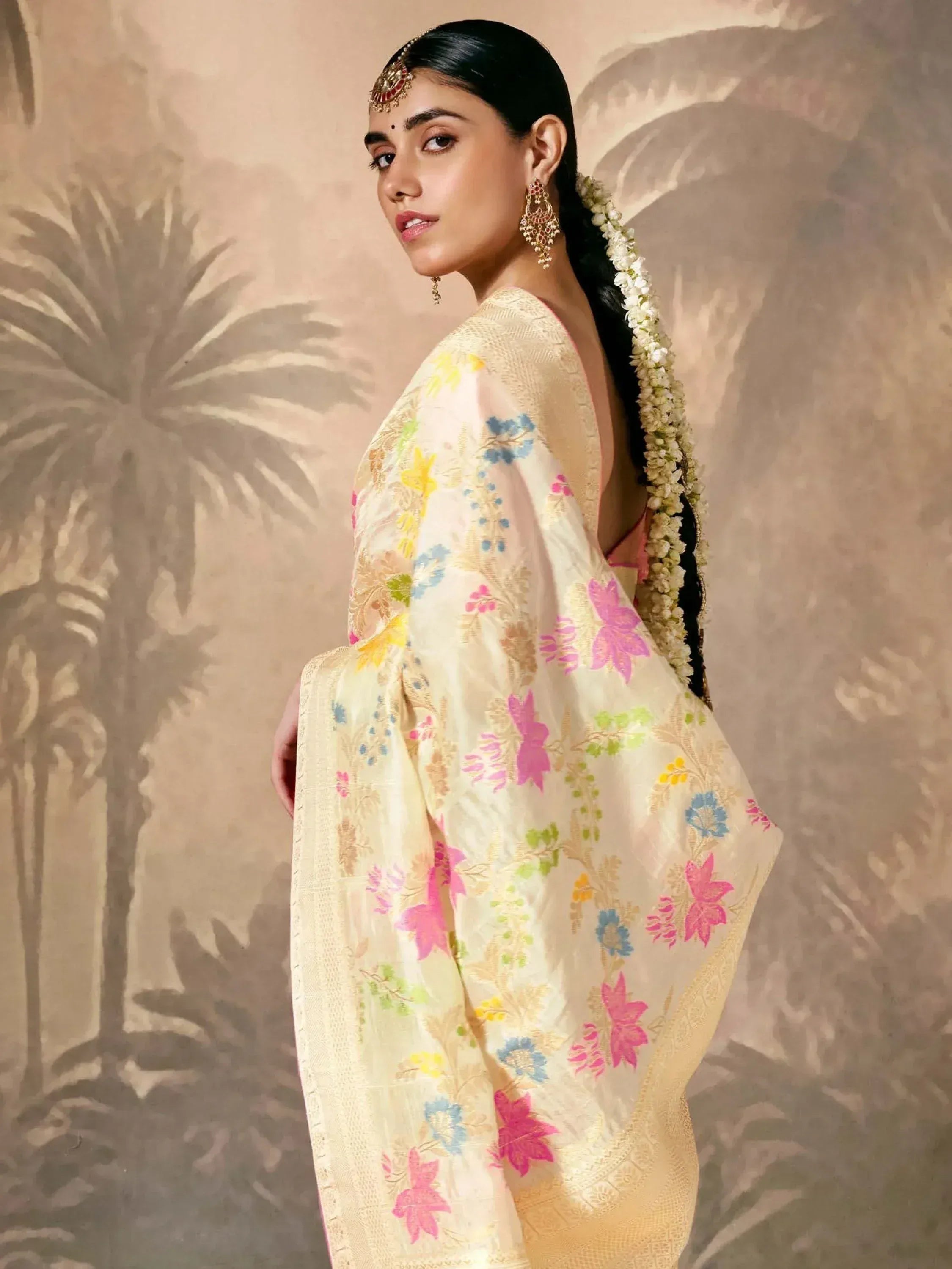 Woman in floral embroidered saree with gold border, traditional Indian ethnic wear, floral hair garland, temple jewelry