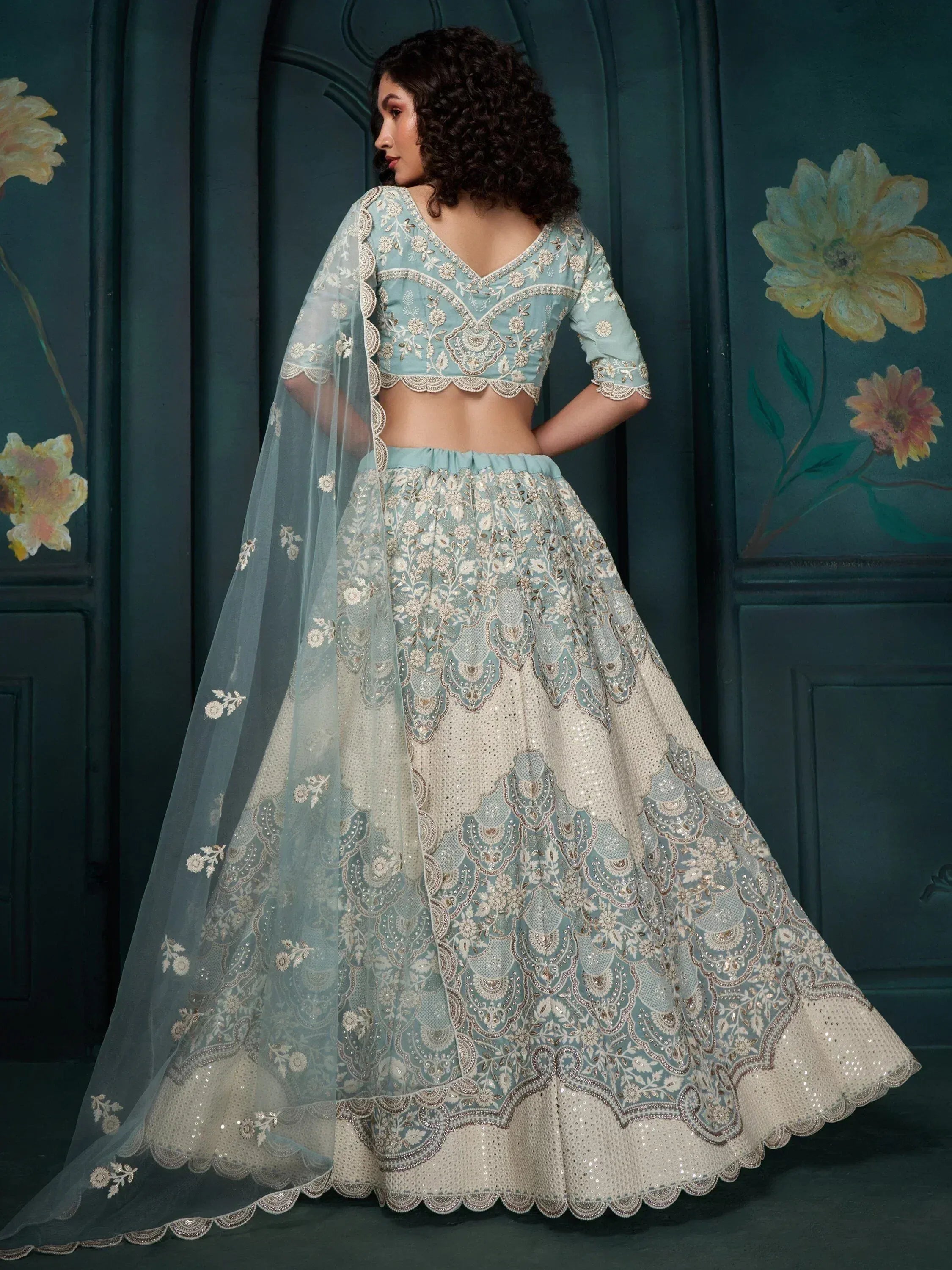 Elegant light blue and ivory embroidered lehenga choli with sheer dupatta, perfect for Indian weddings and festive occasions.