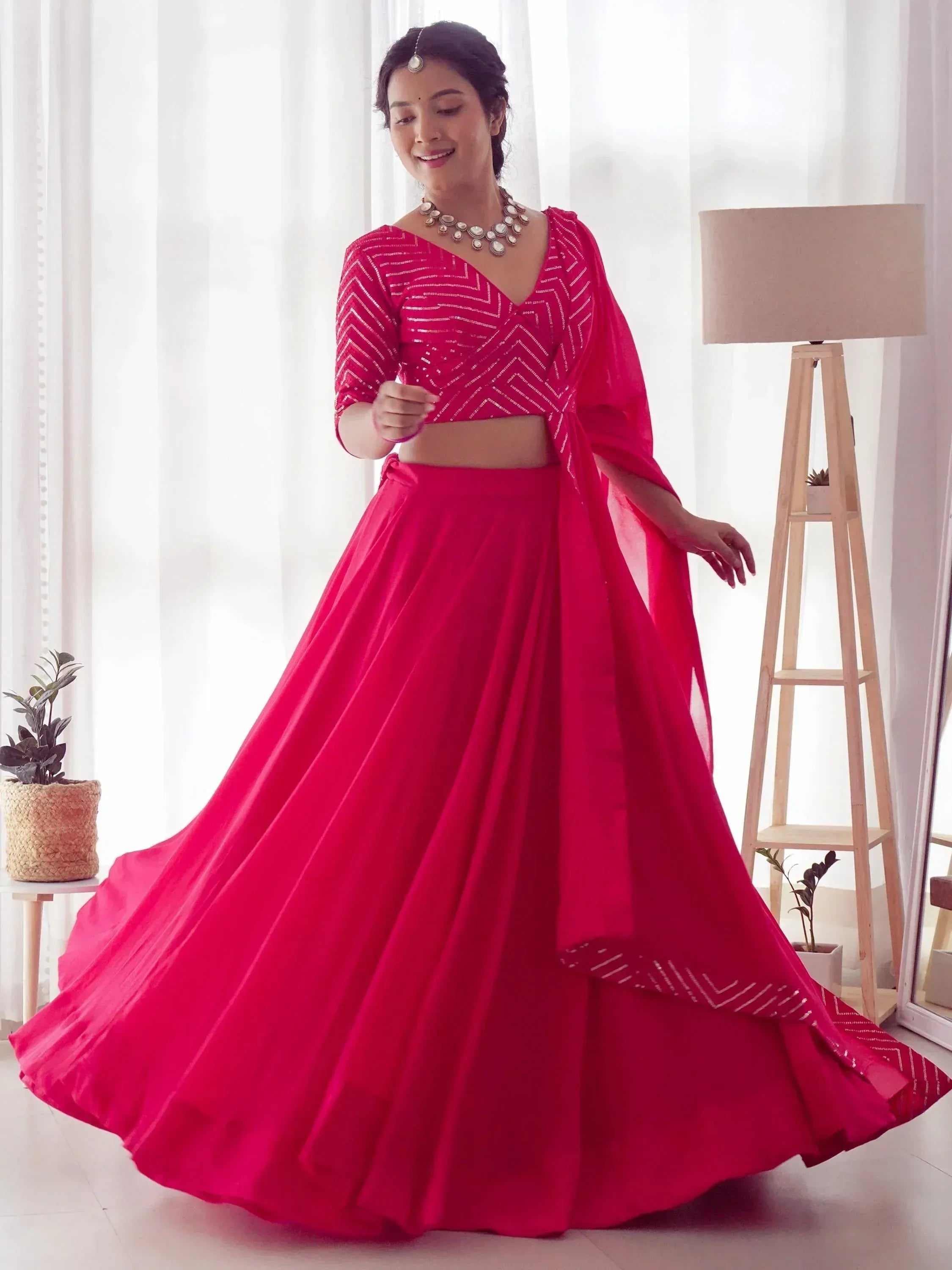 Vibrant pink designer lehenga choli with geometric embroidery, perfect for Indian ethnic occasions.