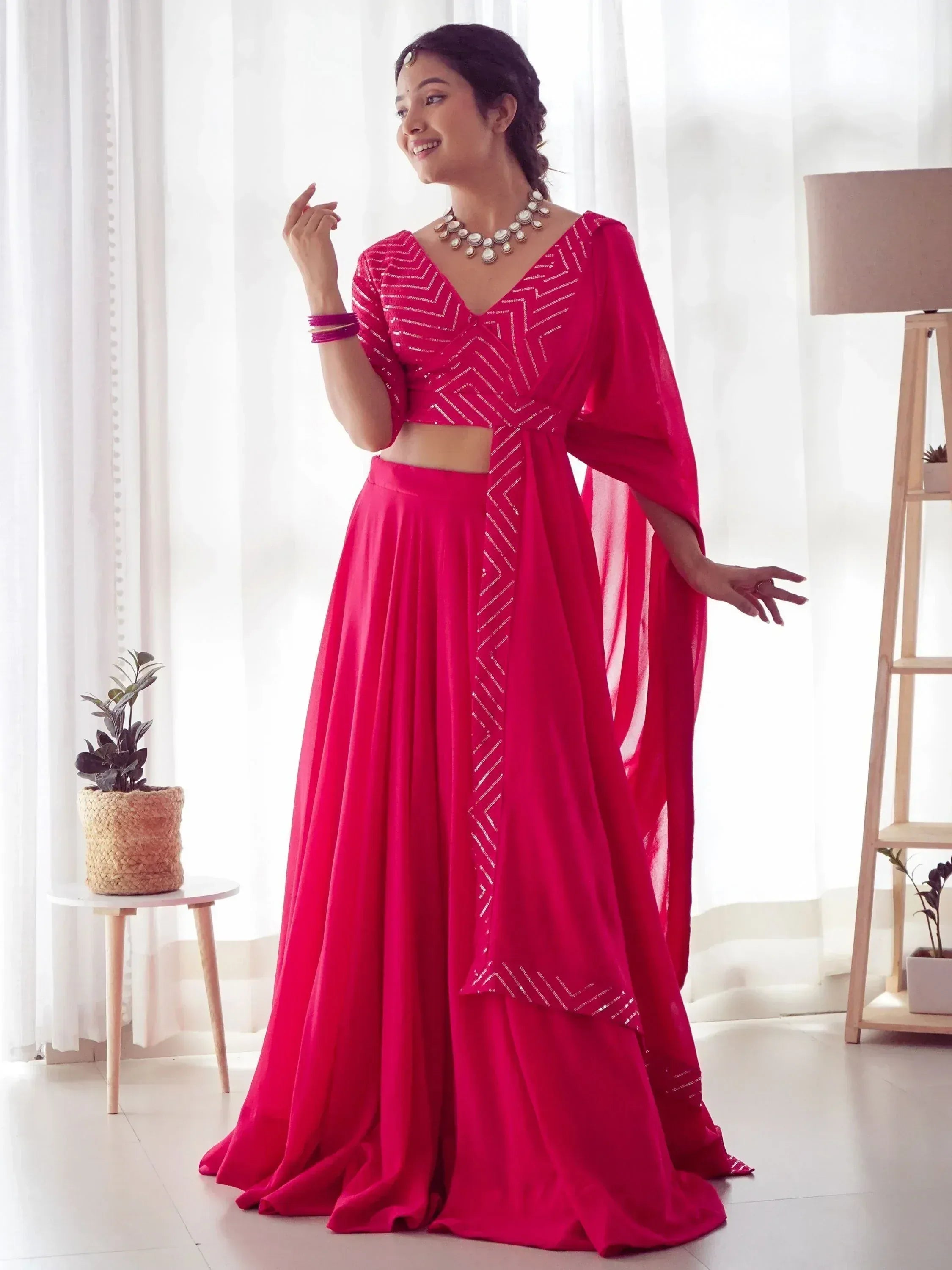 Woman in vibrant pink ethnic lehenga choli with geometric embroidery, perfect for Indian celebrations