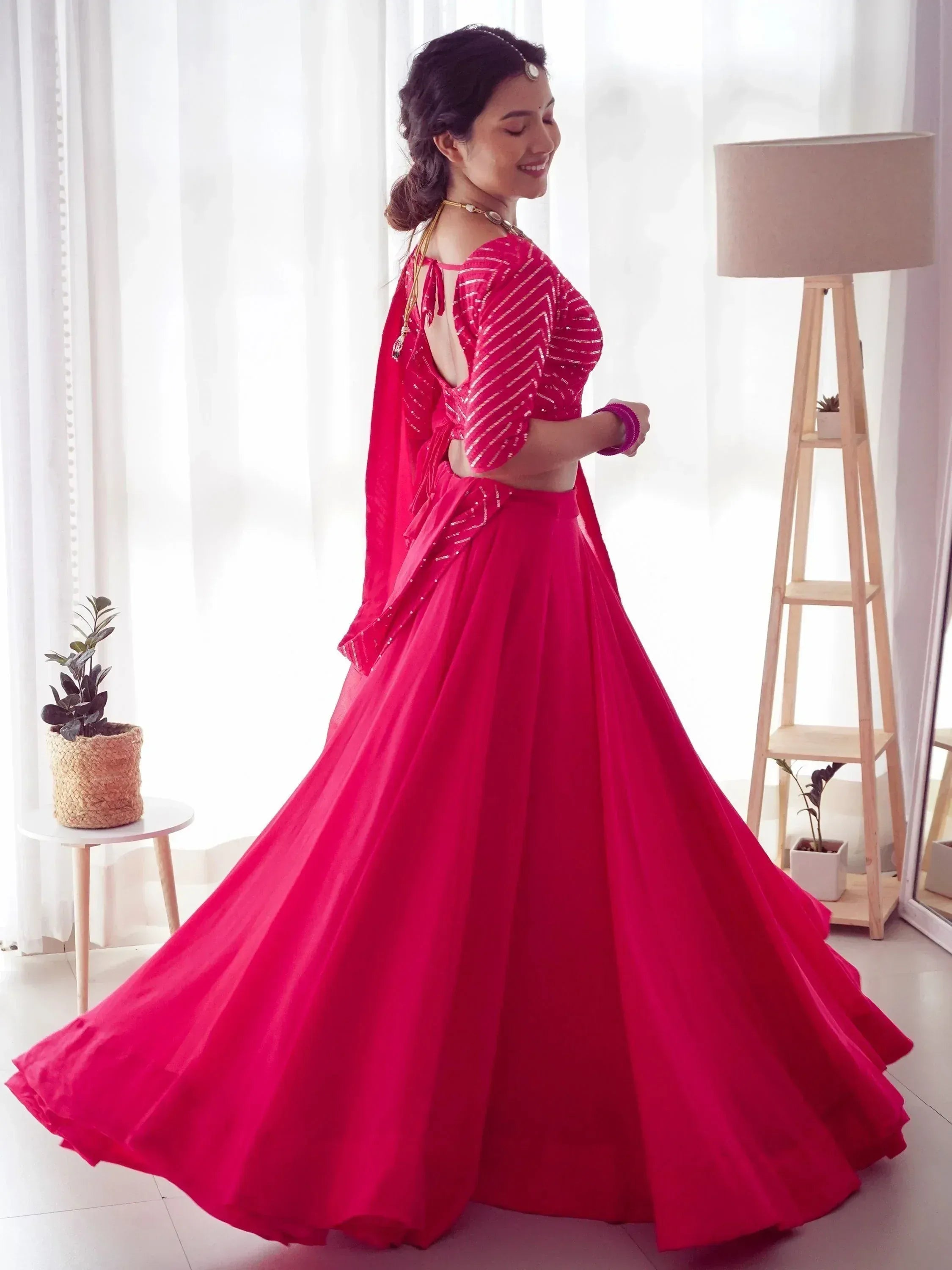 Vibrant pink designer lehenga choli with sequin top and flowing skirt, perfect for Indian ethnic occasions.