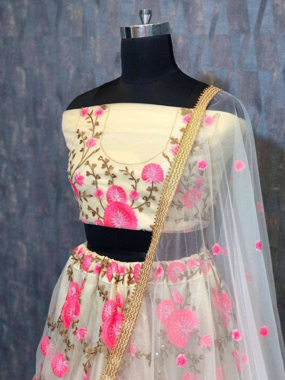 Cream lehenga choli with pink floral embroidery and gold trim, perfect for Indian ethnic wear occasions