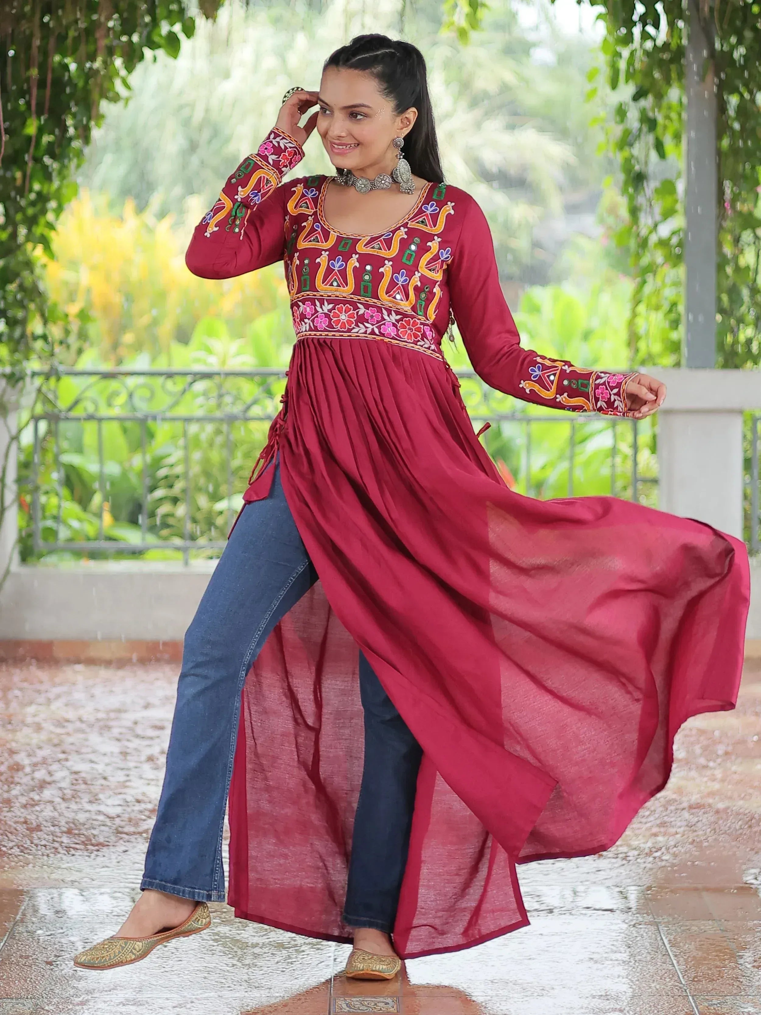 Maroon embroidered ethnic kurta with floral and peacock motifs, paired with jeans and juttis, styled for festive occasions