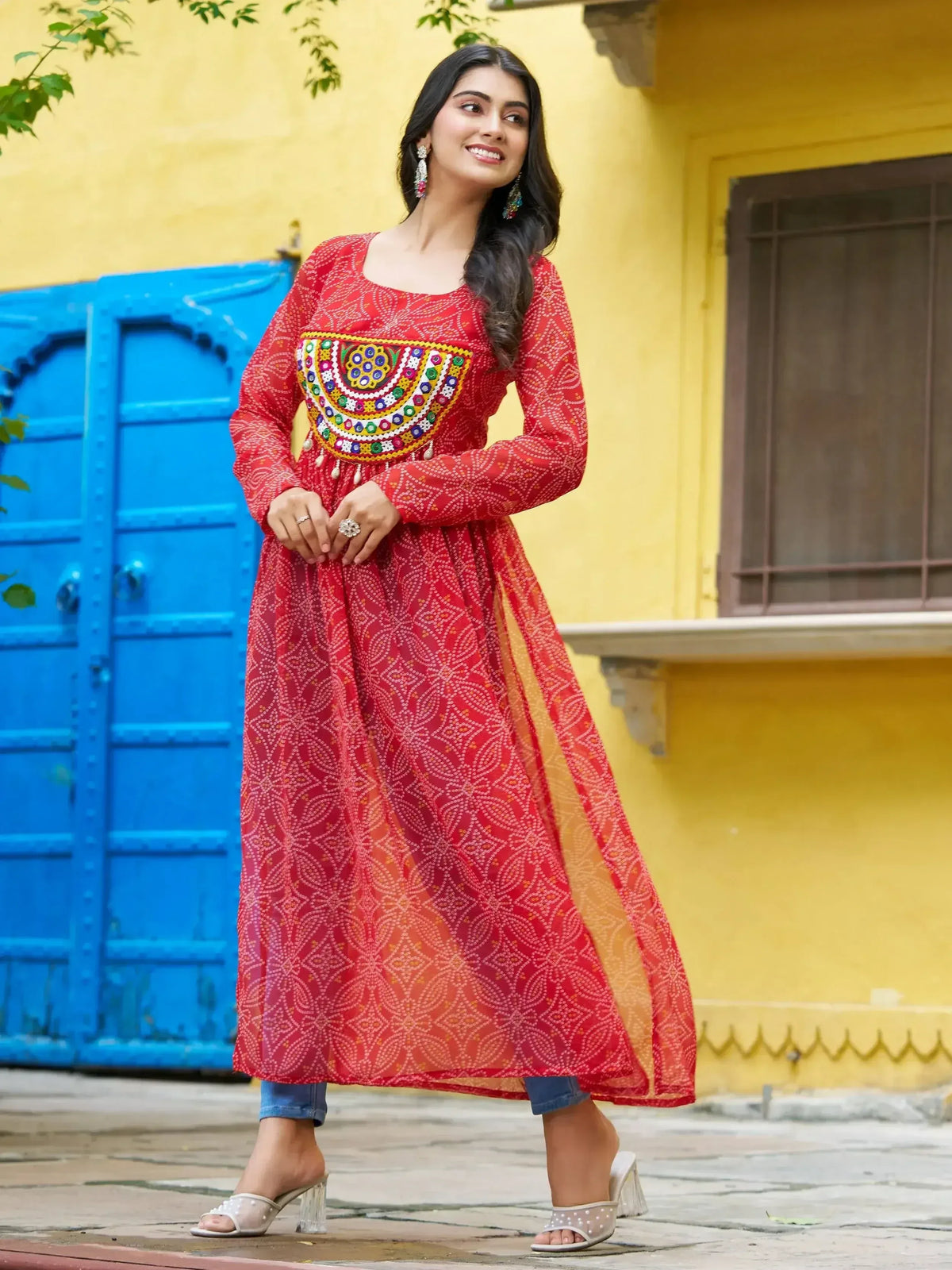 Red ethnic anarkali with mirror work and printed patterns, paired with jeans and heels for a fusion look