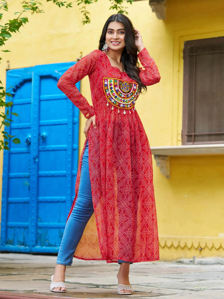 Red embroidered ethnic kurti with mirror work, paired with jeans, perfect for casual Indian wear