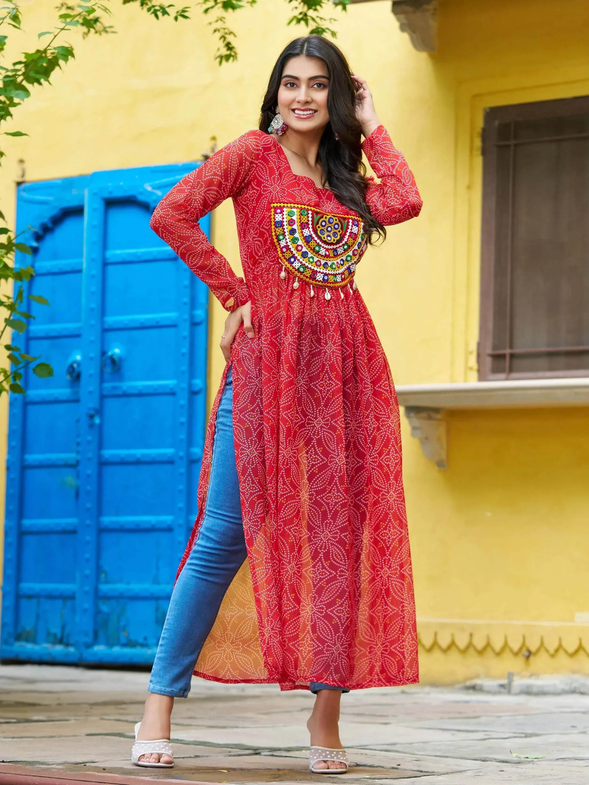 Red embroidered ethnic kurti with mirror work, paired with jeans, perfect for casual Indian wear