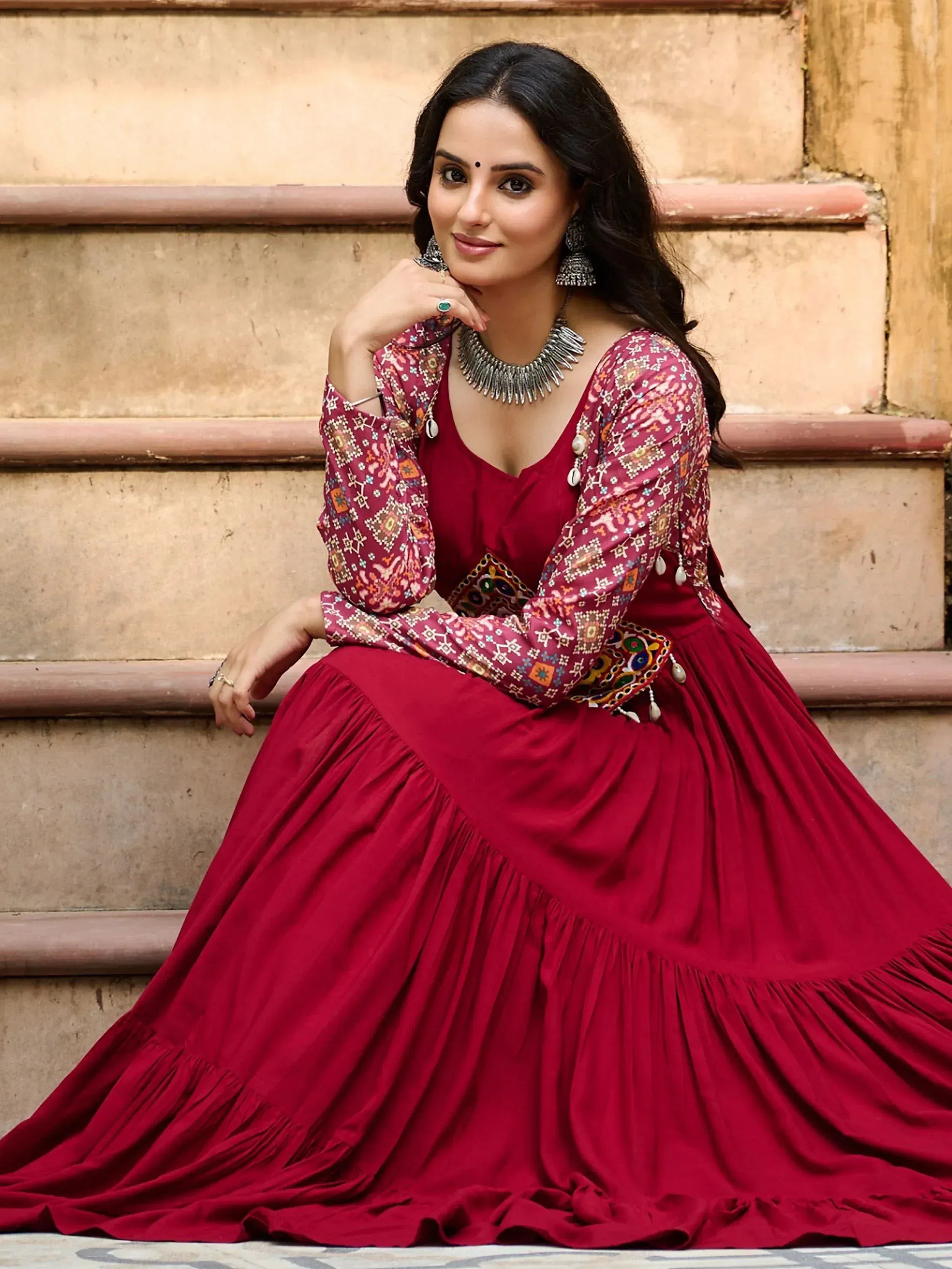 Woman in maroon ethnic gown with printed sleeves, perfect for Indian occasions and festive wear