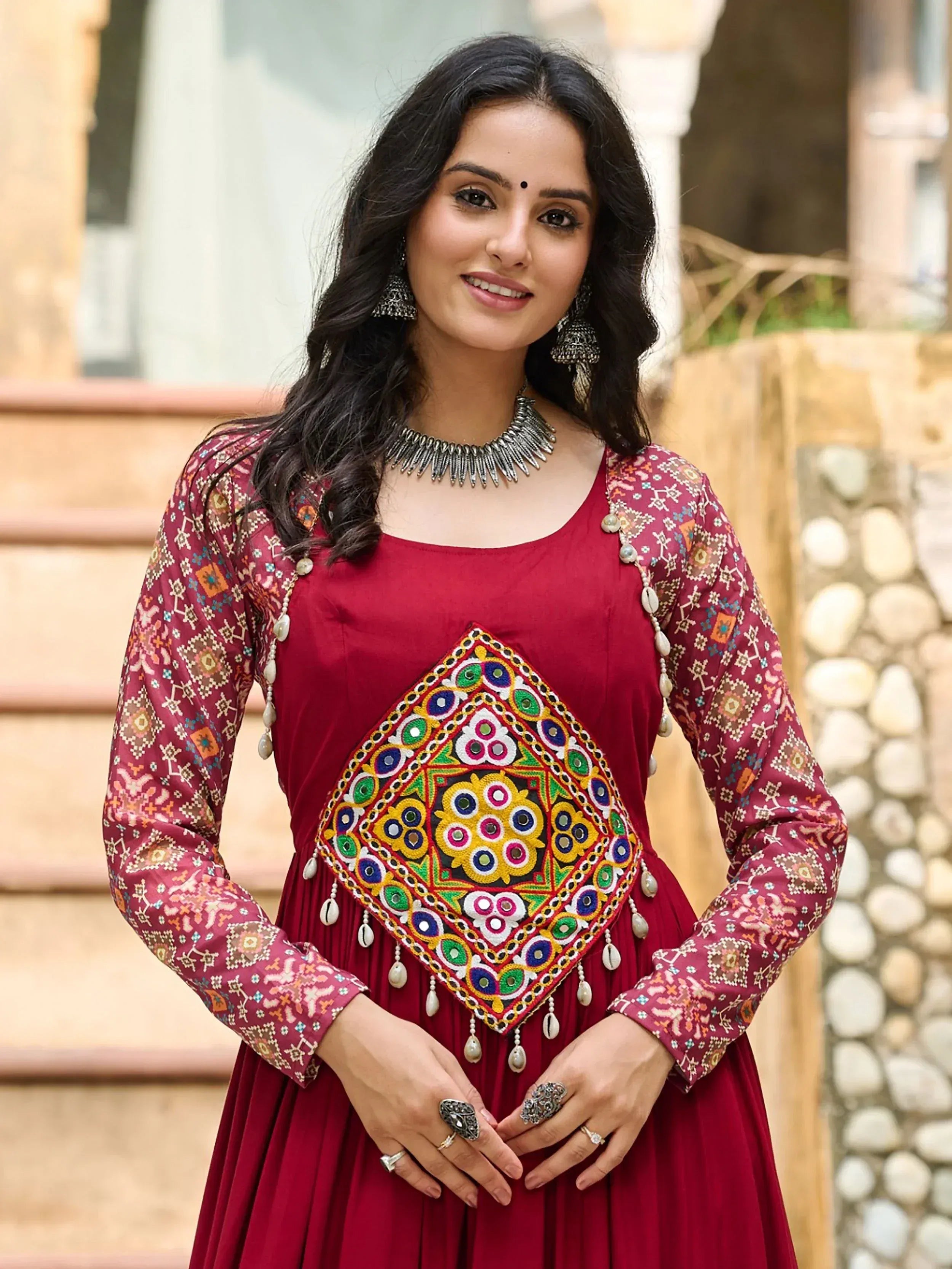 Maroon ethnic gown with mirror work and printed sleeves, perfect for Indian festive occasions