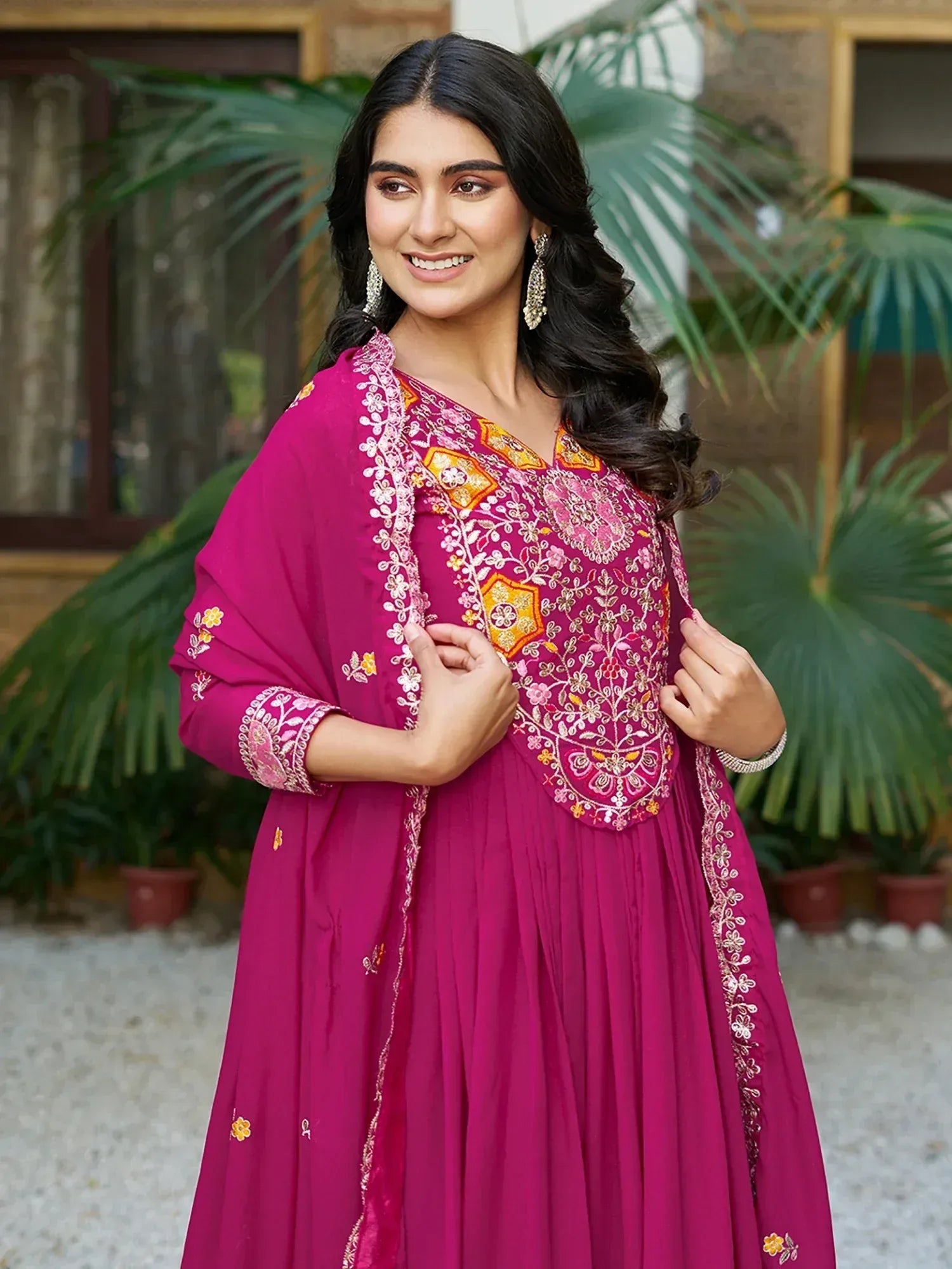 Woman in magenta embroidered ethnic gown with floral details, perfect for Indian occasions