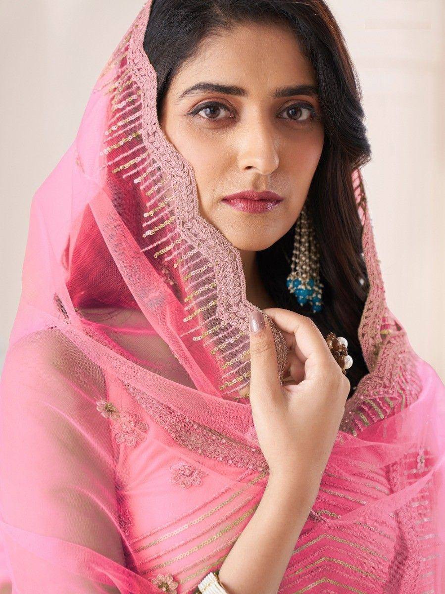 Pink embroidered saree with gold detailing and matching dupatta, styled with traditional Indian jewelry