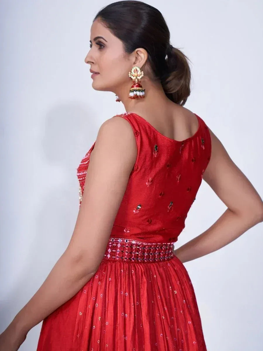 Red ethnic gown with embellished back and waistband, paired with traditional jhumka earrings