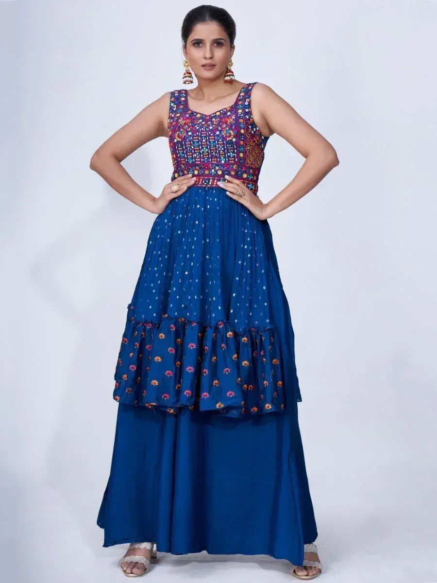 Woman wearing a blue ethnic gown with multicolor embroidered bodice and tiered skirt
