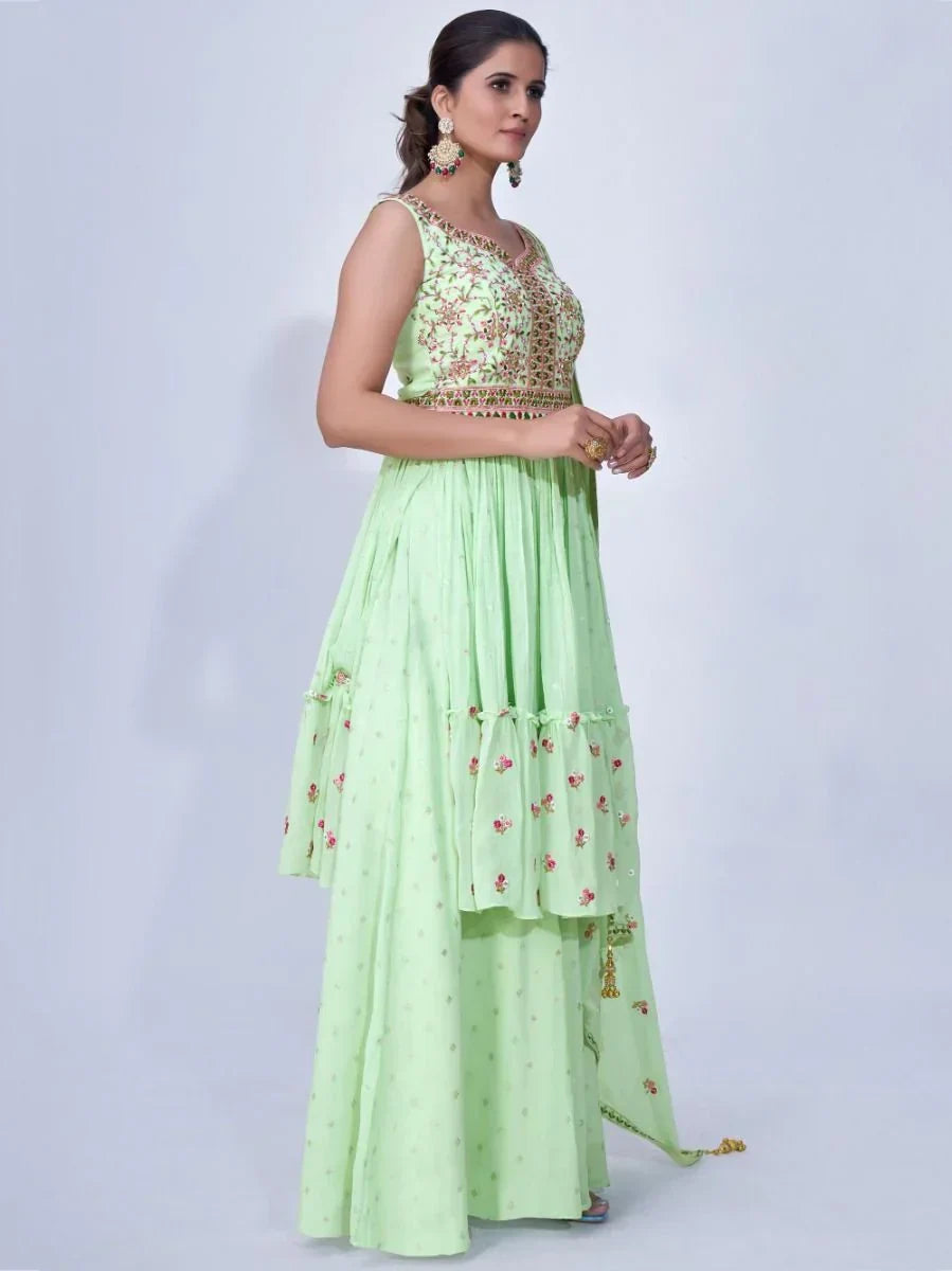 Woman wearing a pastel green embroidered ethnic lehenga dress with floral patterns