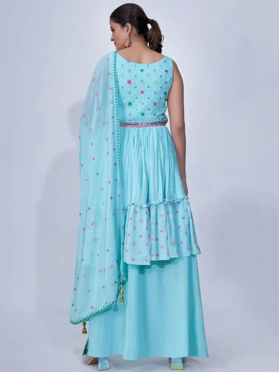 Woman in light blue lehenga choli with floral embroidery and matching dupatta, rear view