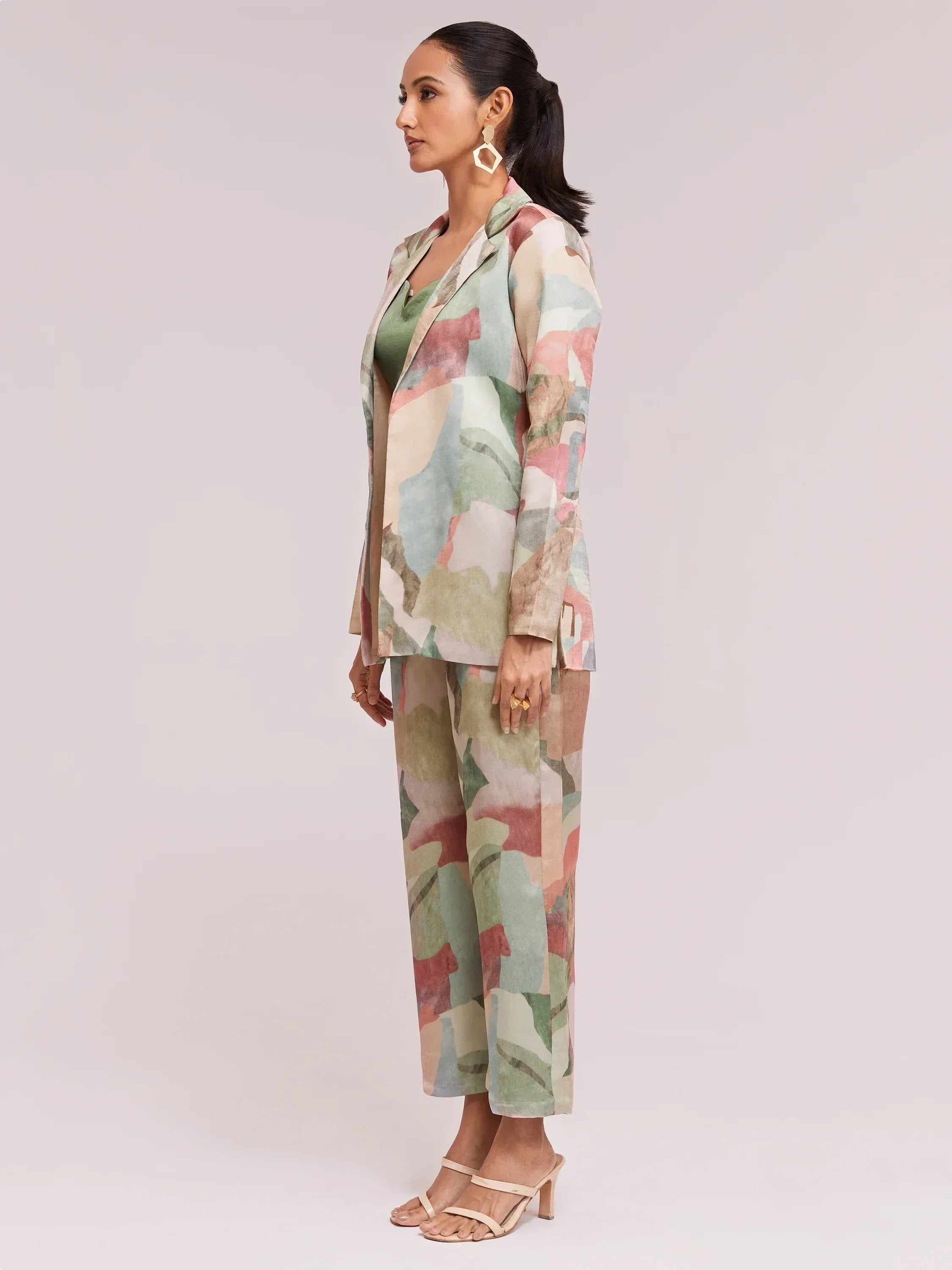 Woman in printed ethnic pantsuit with blazer, green top, and heels