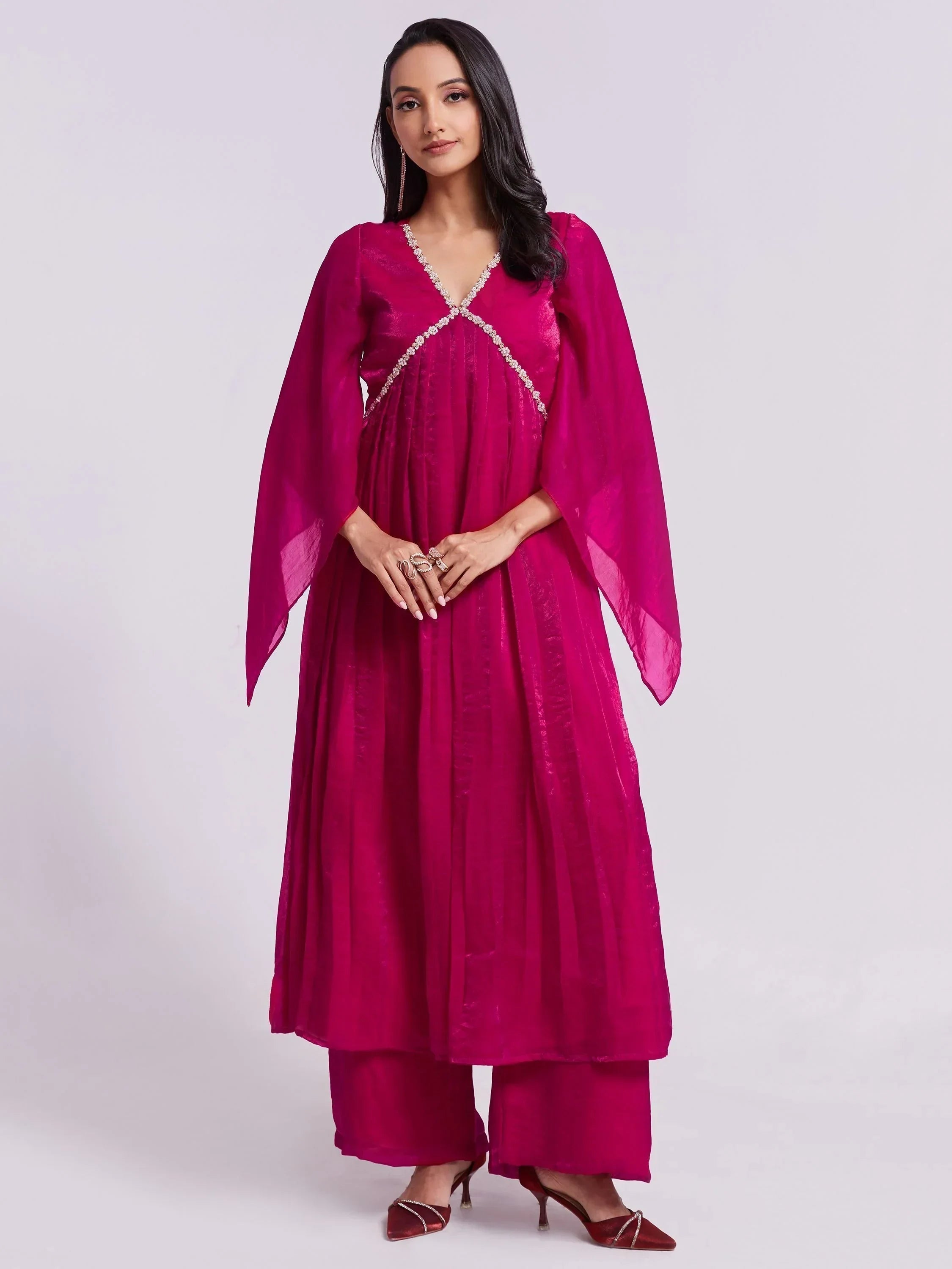 Woman wearing magenta flowy kurta with palazzo pants, ethnic Indian party wear outfit