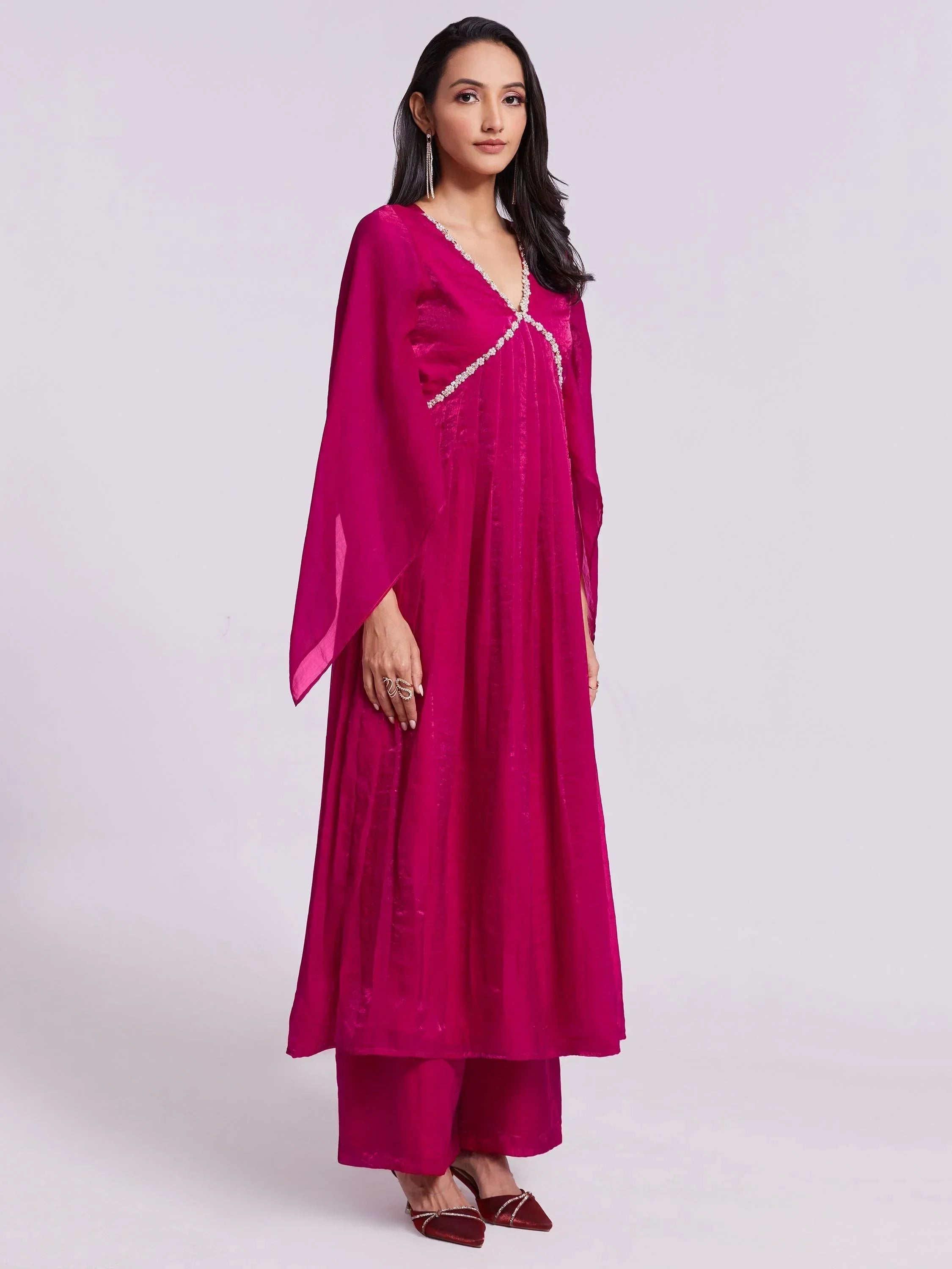 Woman wearing a magenta ethnic kurta set with flared sleeves and palazzo pants