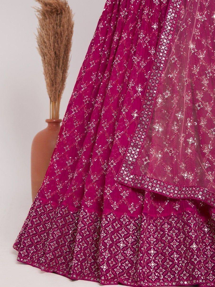 Fuchsia lehenga choli with intricate silver embroidery and sheer dupatta, perfect for Indian ethnic wear occasions.