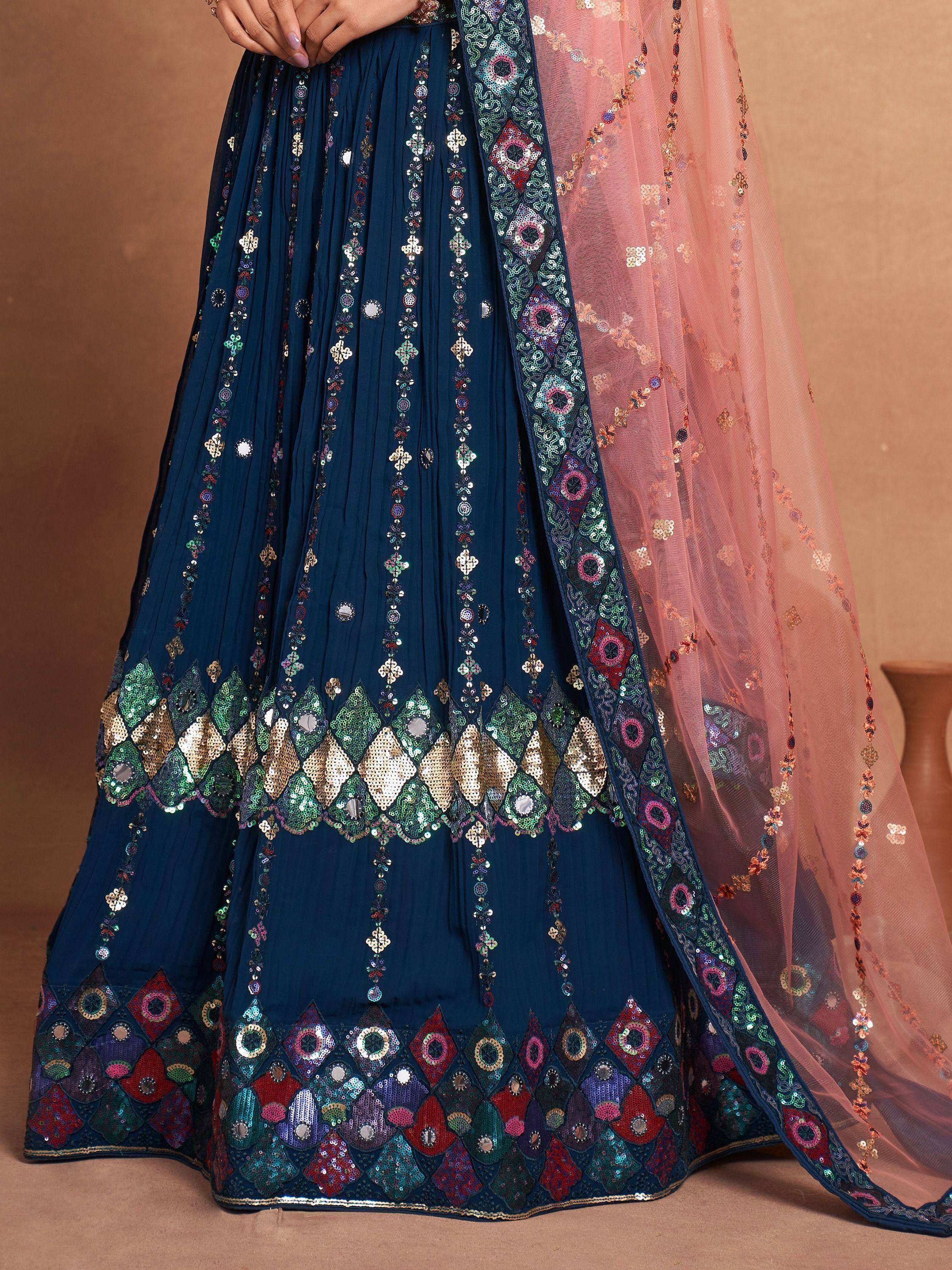 Navy blue lehenga with colorful mirror and sequin embroidery, paired with pink dupatta for Indian ethnic wear